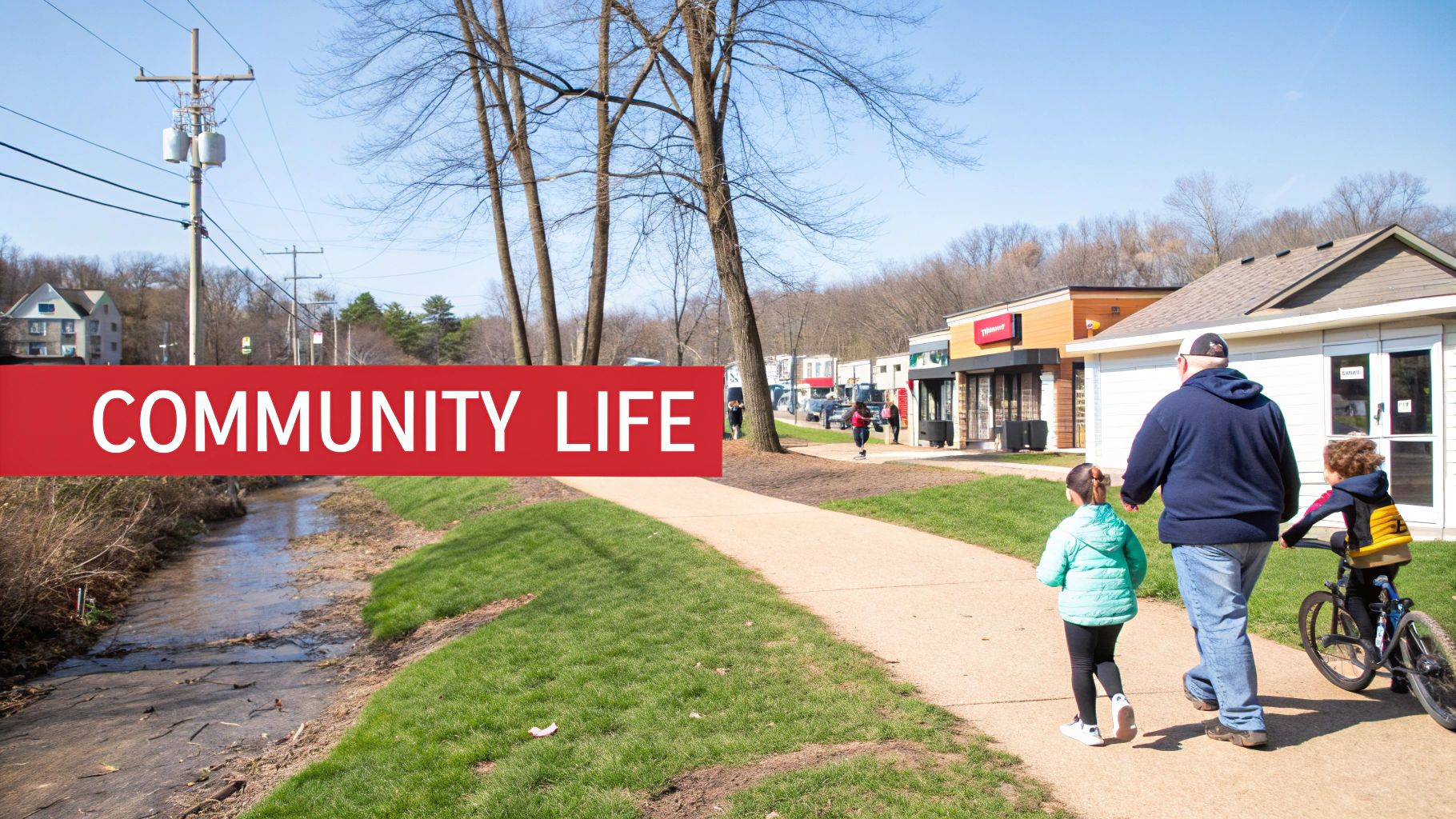 A family walks on a sunny day along a path in a lively community area.