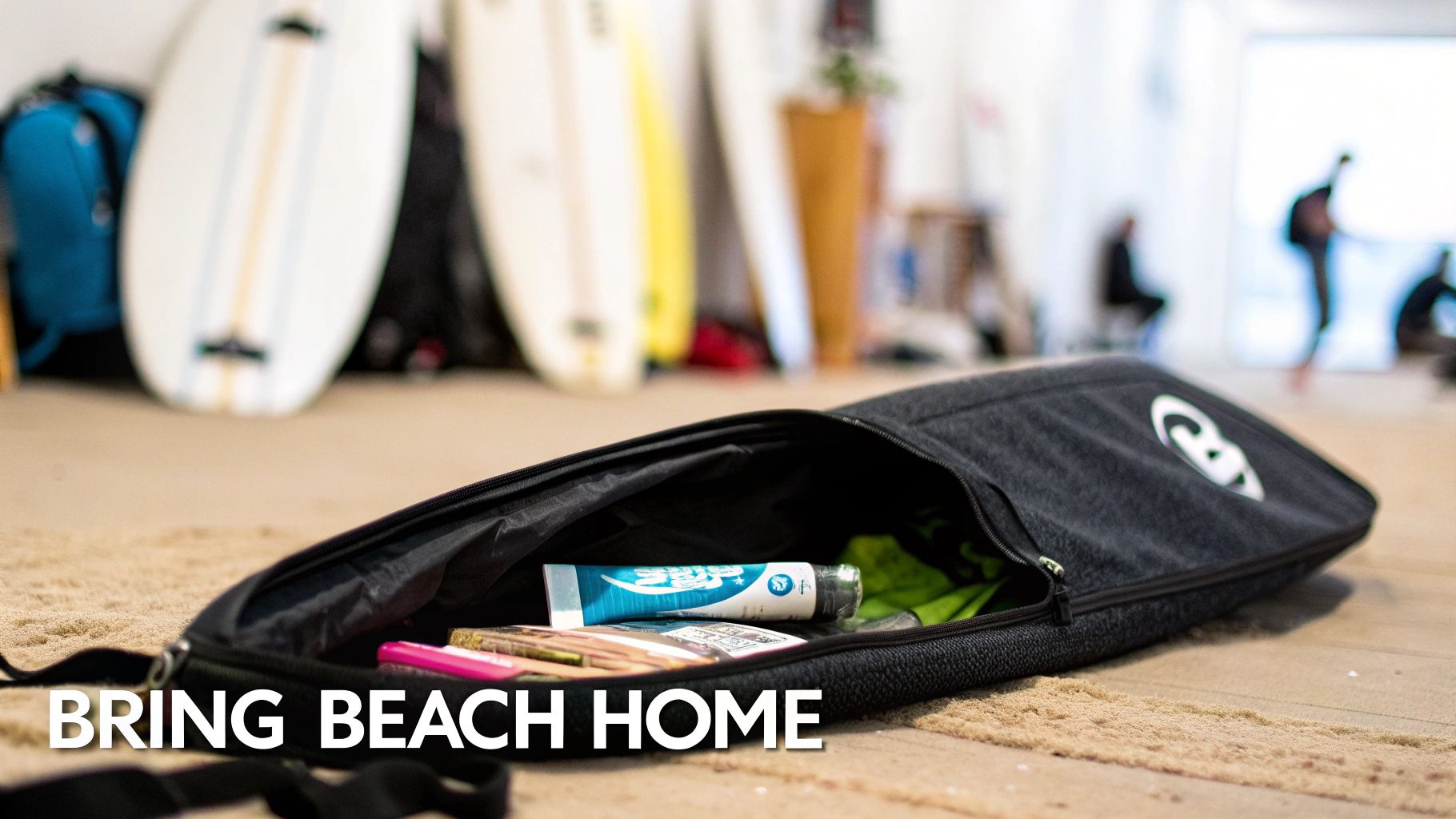 An open black surf bag containing beach essentials and a Sexwax product, resting on sand with surfboards in the background.