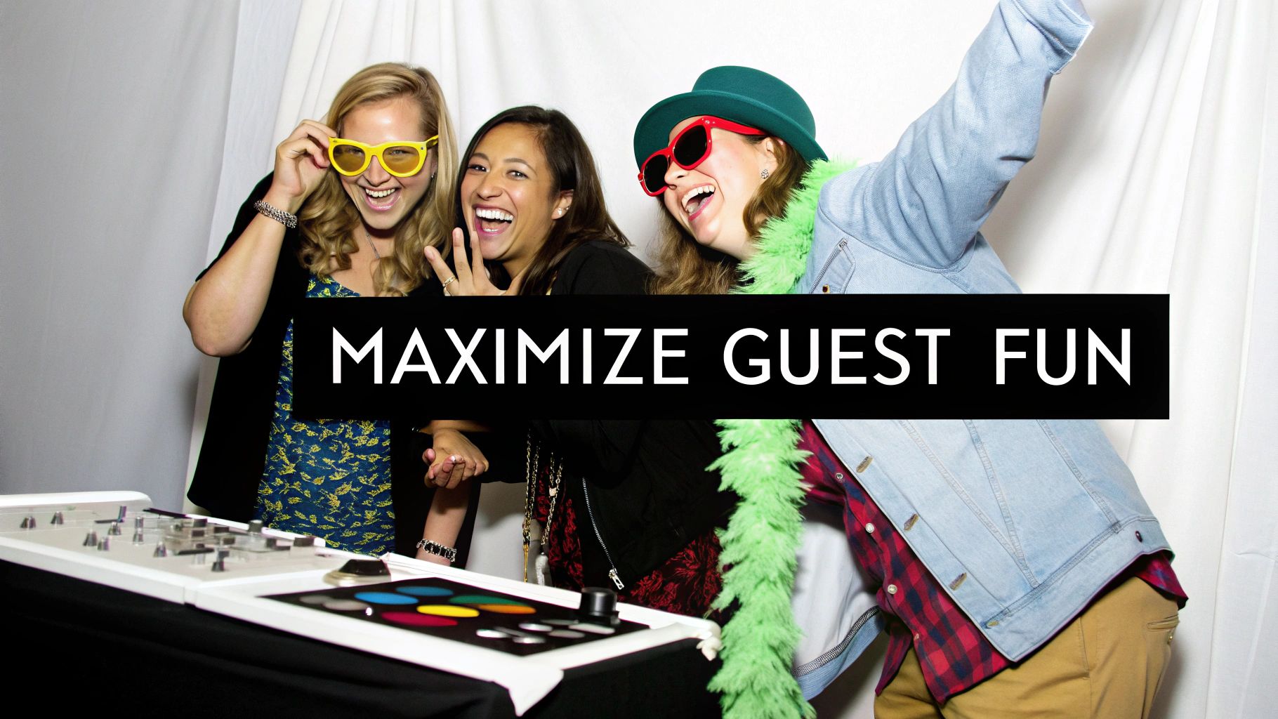 Three smiling women enjoying a photo booth, wearing fun props and engaging with the booth controls.