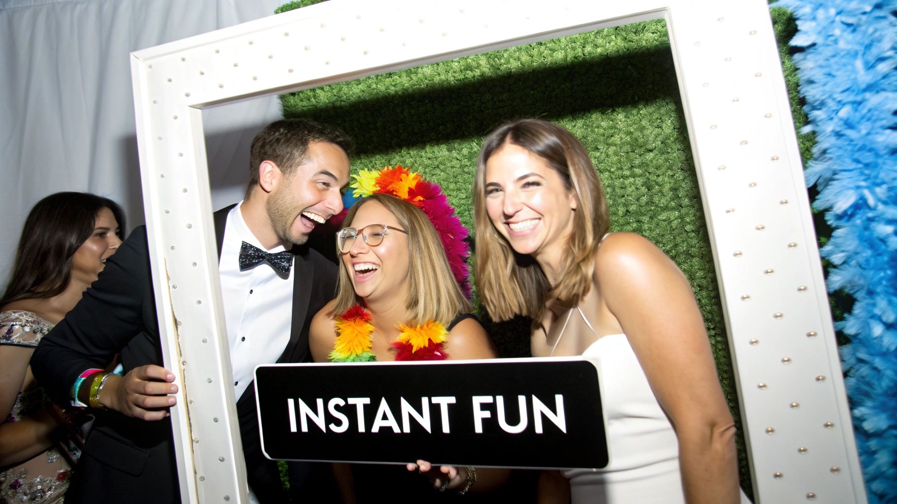 A close-up of a mirror photo booth showing a vibrant touchscreen with animated graphics, inviting guests to interact.