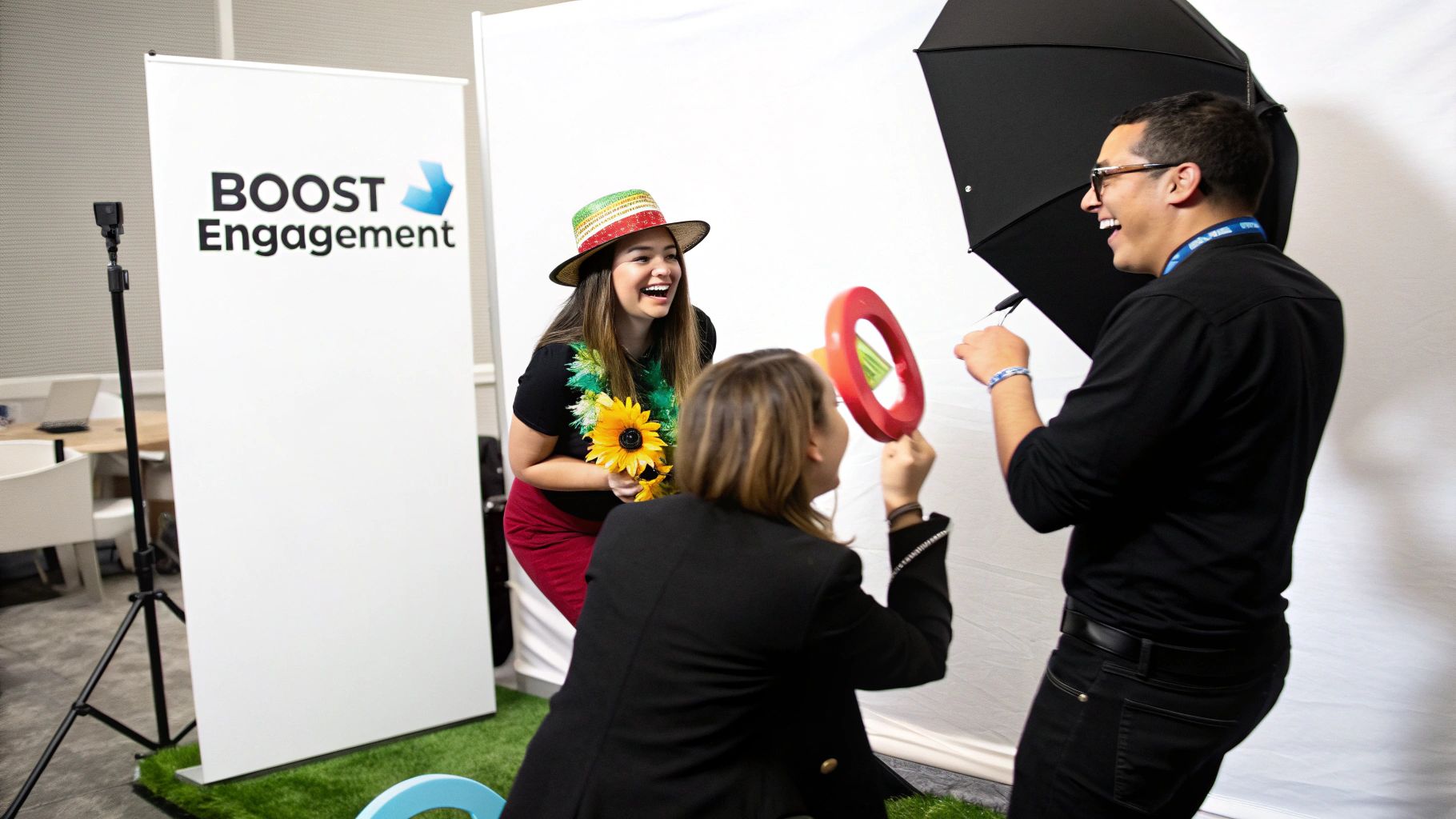 Three happy people interacting at a photo booth setup with a 'BOOST Engagement' banner.