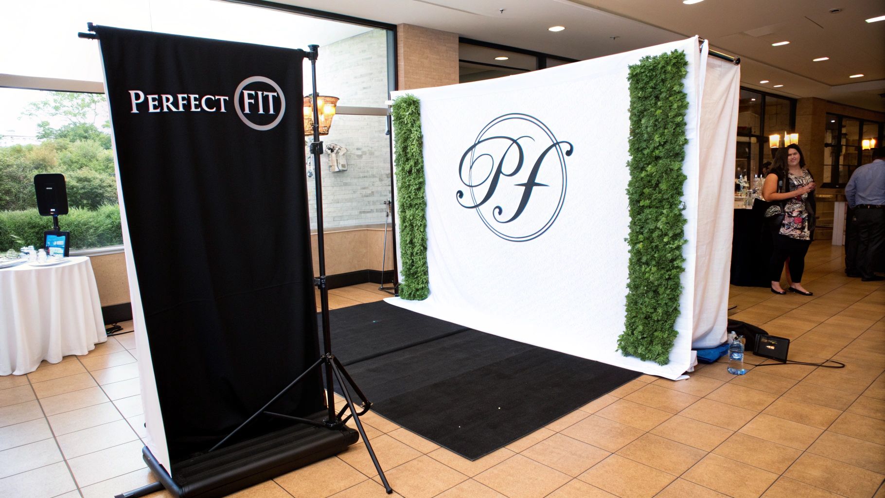 A stylish custom backdrop for a photo booth featuring a company logo and brand colours at a corporate event.