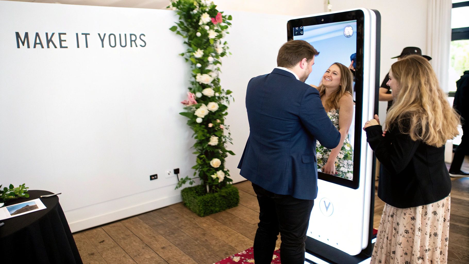 A couple poses for a photo in front of a white magic mirror photo booth at an event.