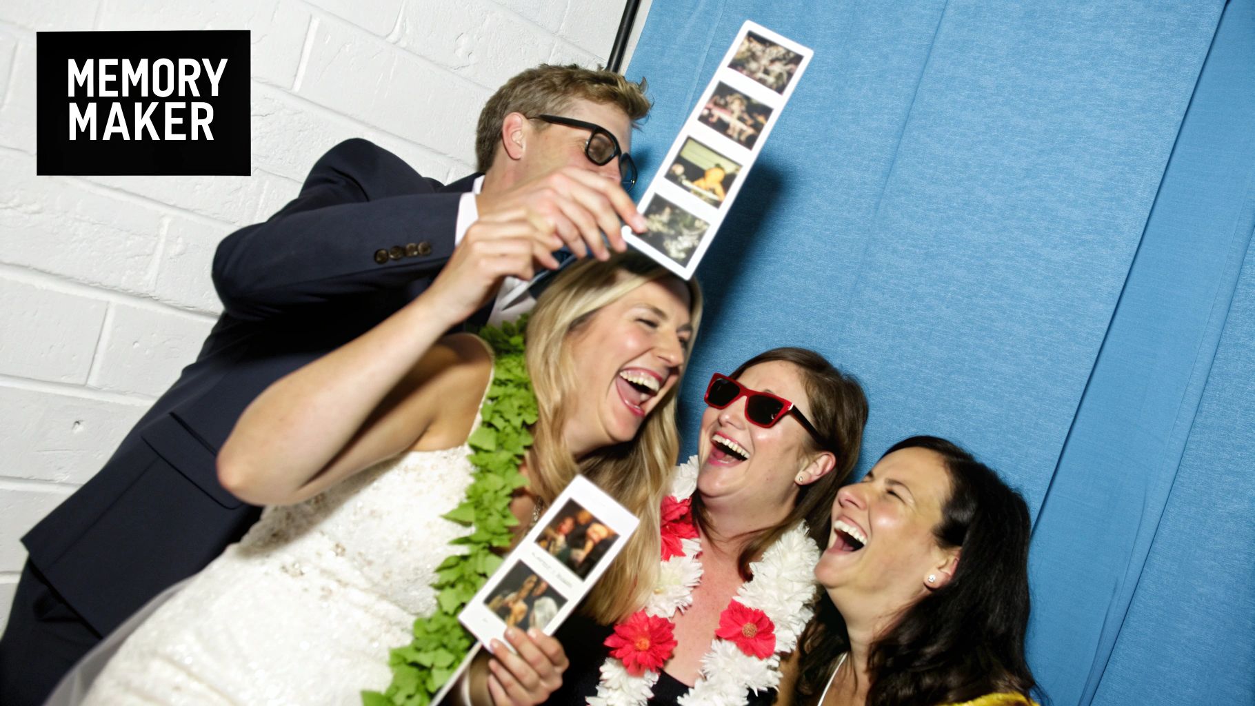 A bride and groom laughing together in a wedding photo booth.