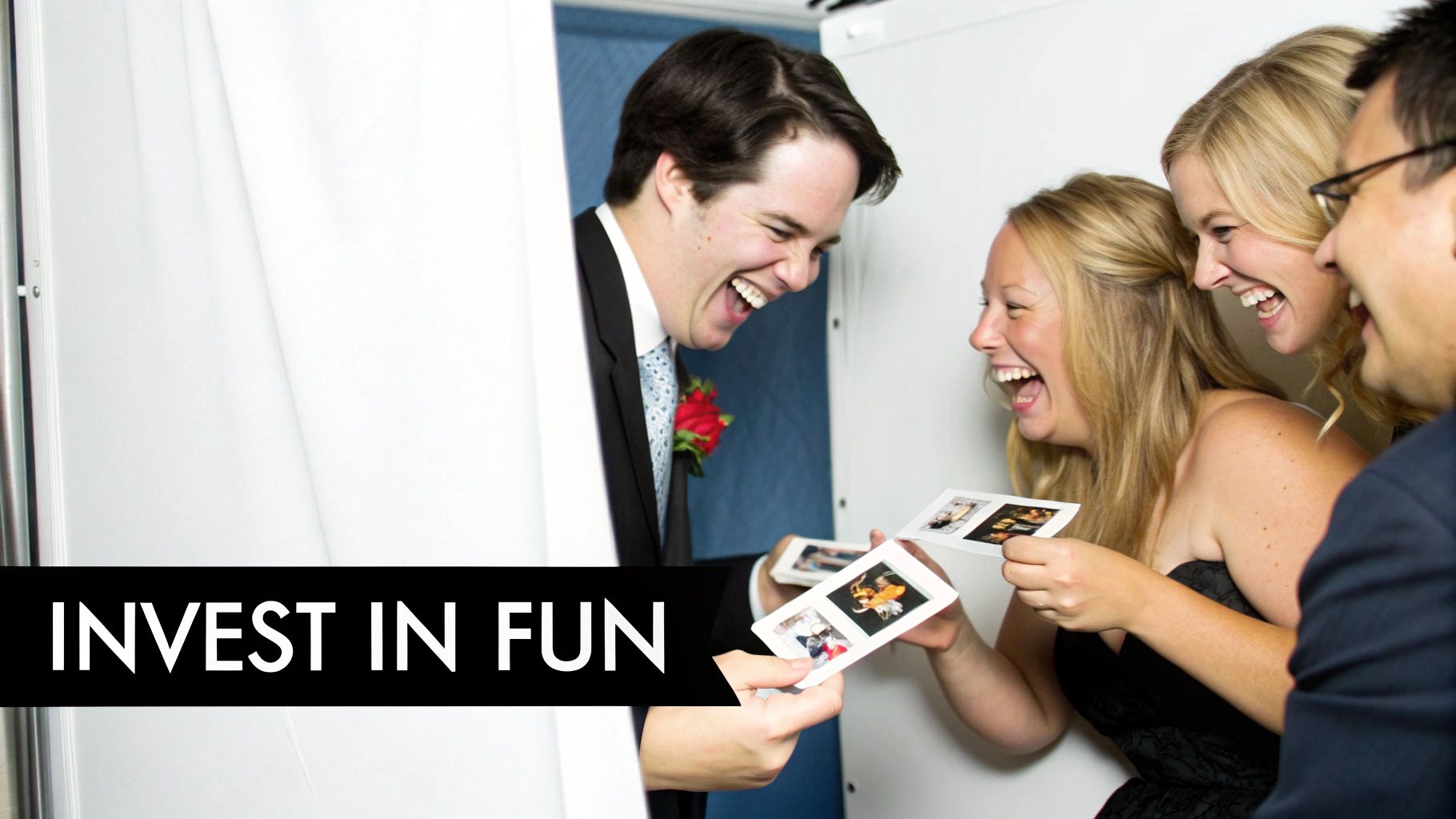 A joyous groom and three women laughing heartily while looking at fun photo booth pictures.