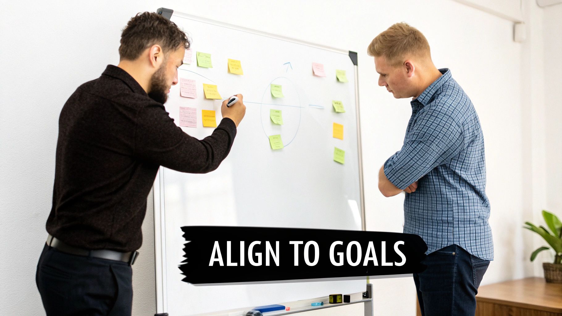 Two men collaborate on a whiteboard filled with sticky notes, planning to align to goals.