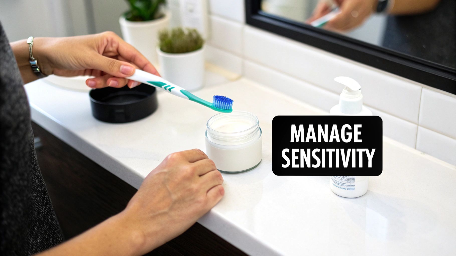 A person dips a toothbrush into a jar of whitening paste on a bathroom counter.