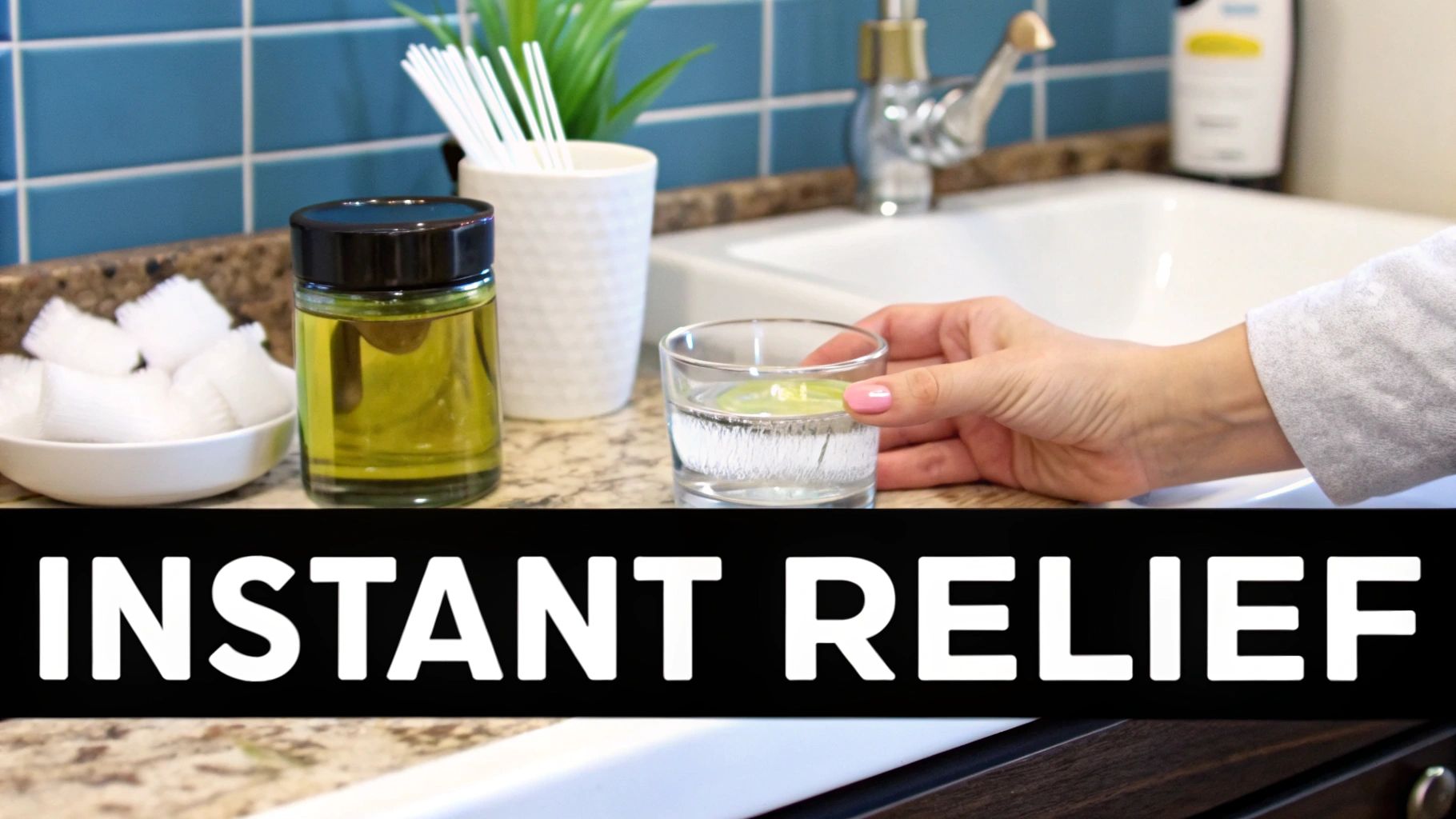 A person holds a glass of water with a lime slice on a bathroom counter with oral care products.