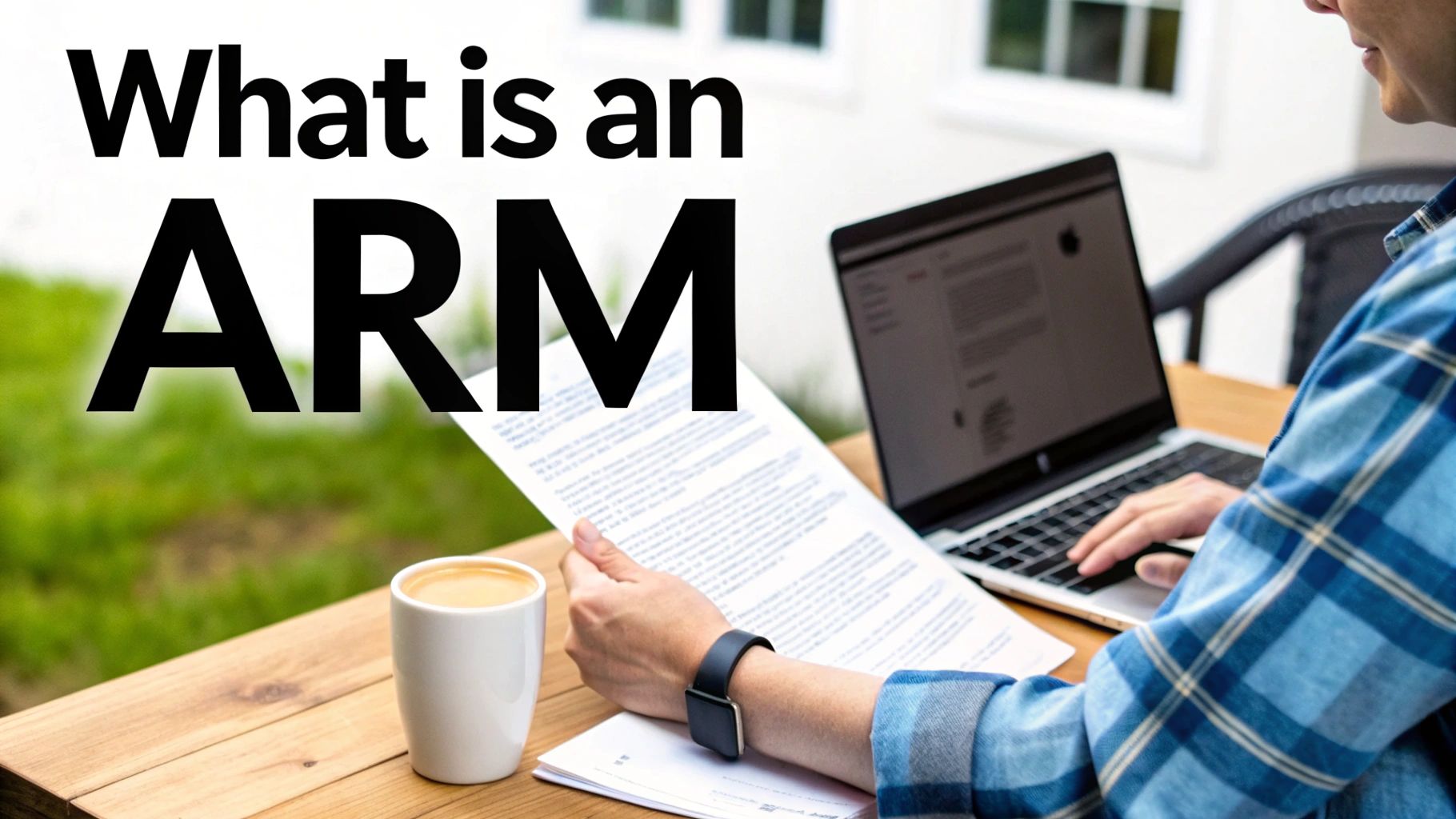 A person sitting outdoors at a wooden table, reading a document and typing on a laptop with a coffee.