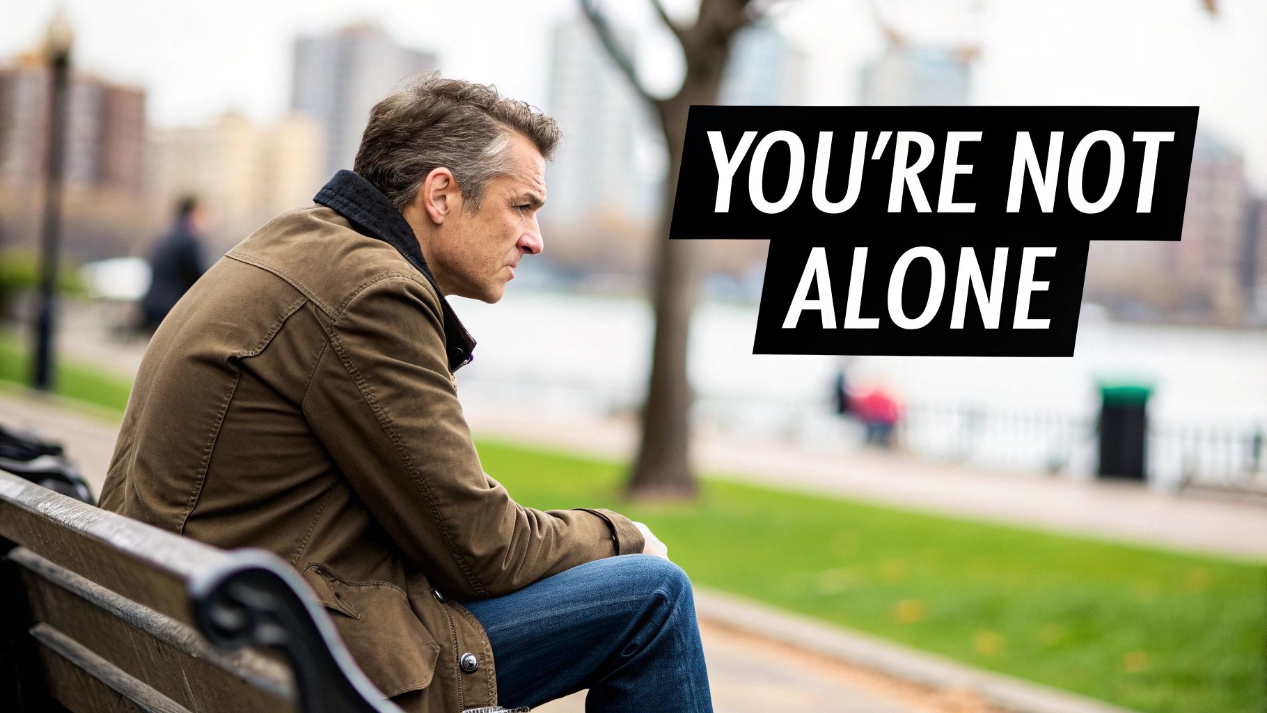A man standing confidently on a mountaintop, looking out at the view.