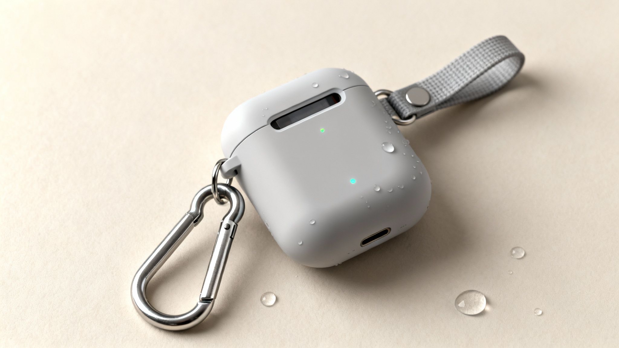 Ανοιχτό γκρι θήκη AirPods με ασημένιο καραμπίνερ και γκρι λουράκι, καλυμμένη με σταγόνες νερού σε μπεζ επιφάνεια.
