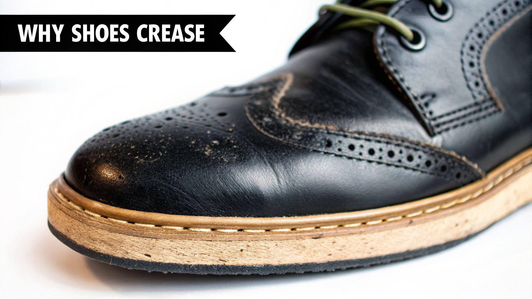Close-up of a black leather brogue shoe showing visible creases and dirt on the vamp and toe area.