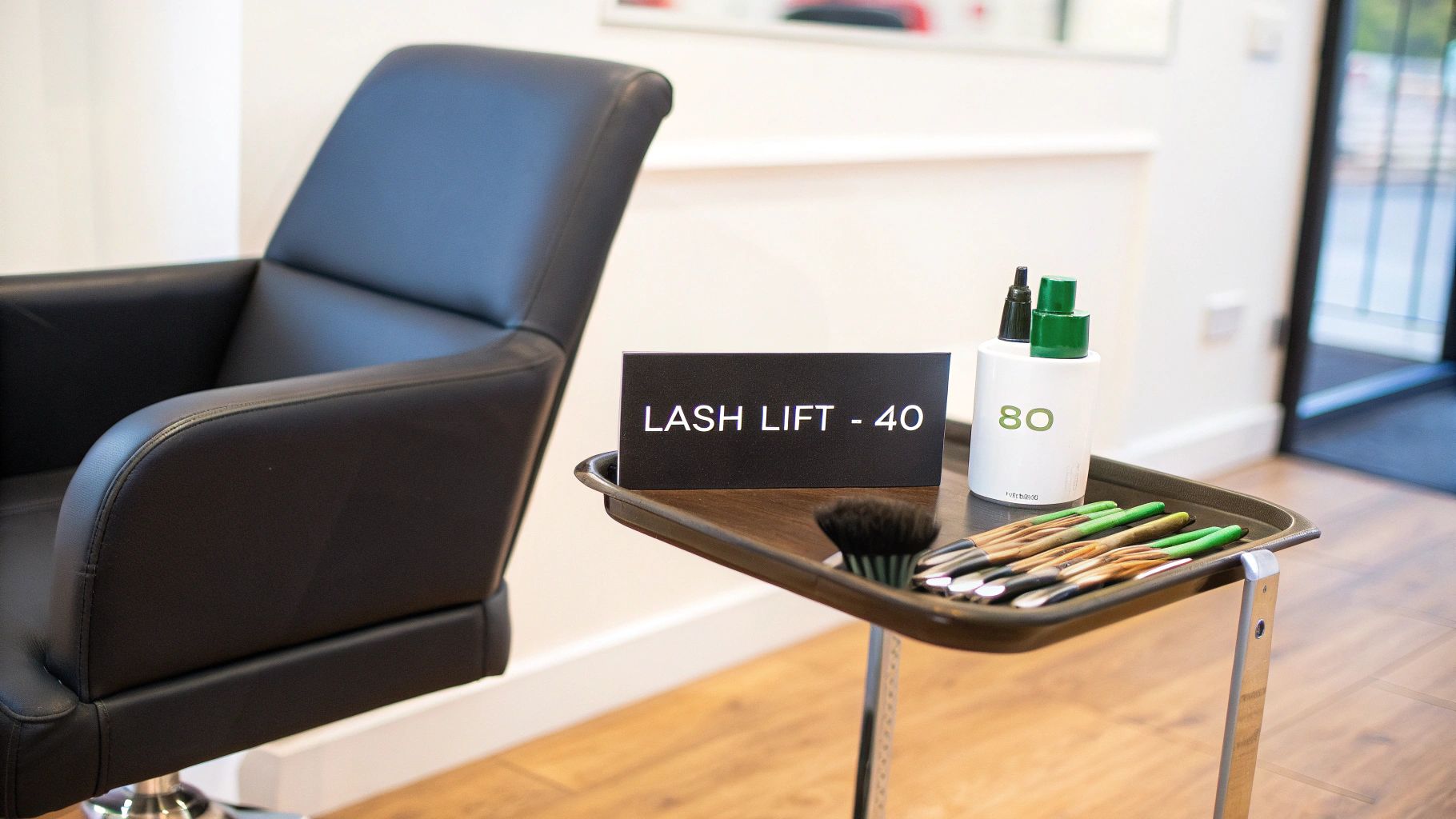 A black salon chair, a table with a 'LASH LIFT - 40' sign, cosmetic bottles, and brushes.