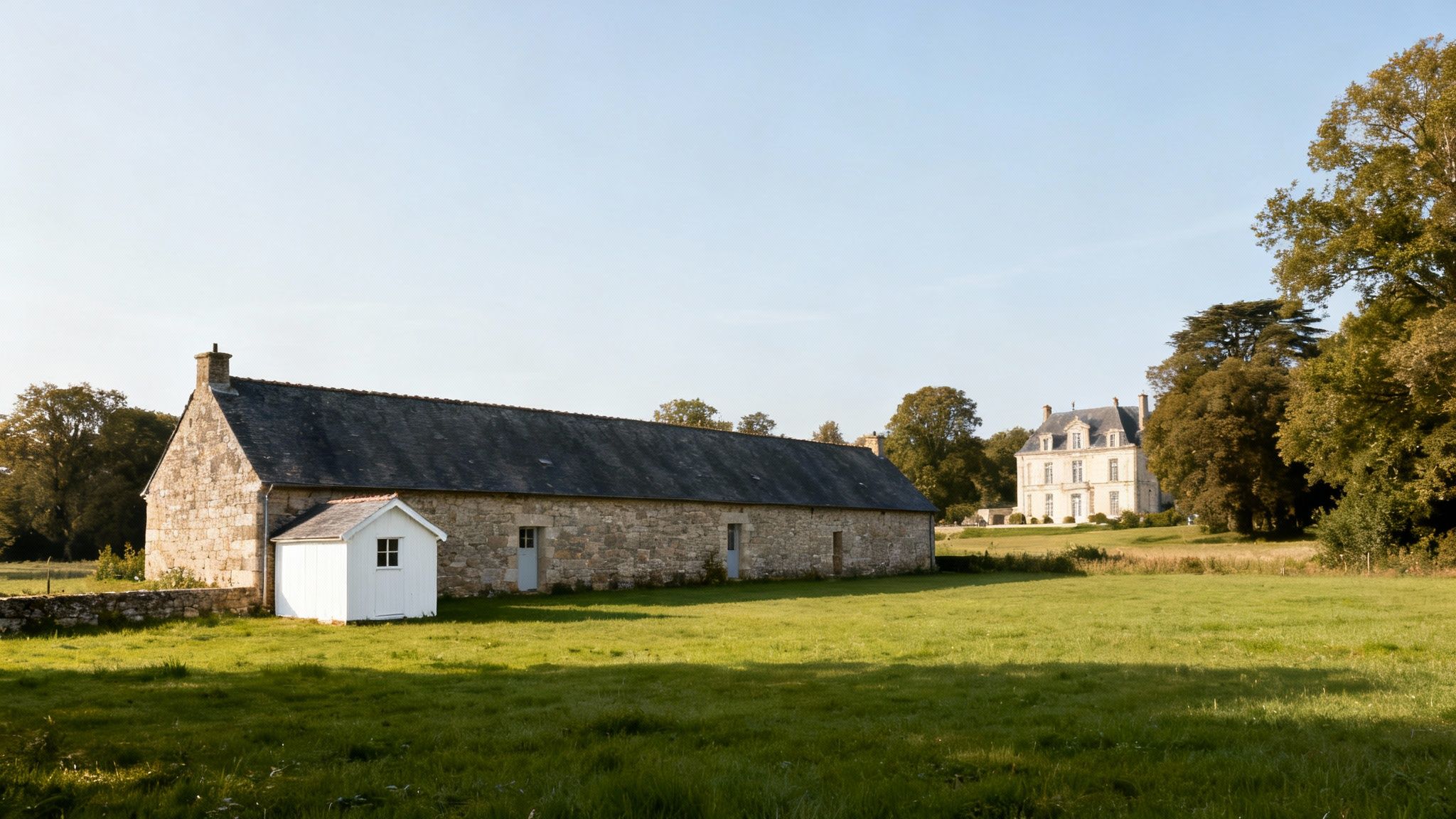 Rustic stone farmhouse with a small white shed and an elegant manor house in the distance.