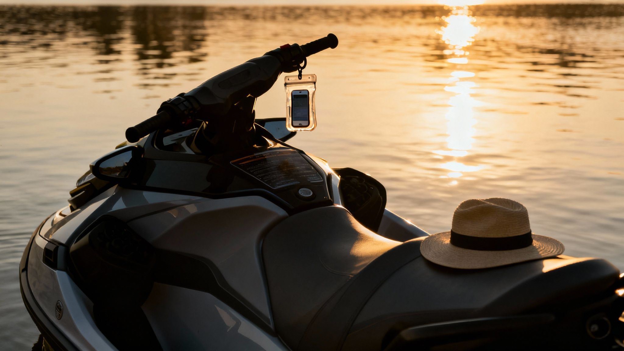 A person on a jet ski making a turn, with the Dubai skyline in the distance.
