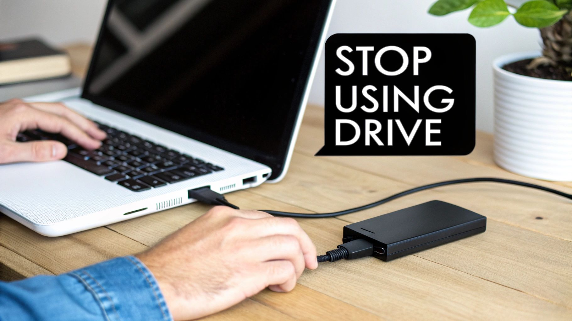 A person connecting an external hard drive to a laptop, with a 'STOP USING DRIVE' warning.