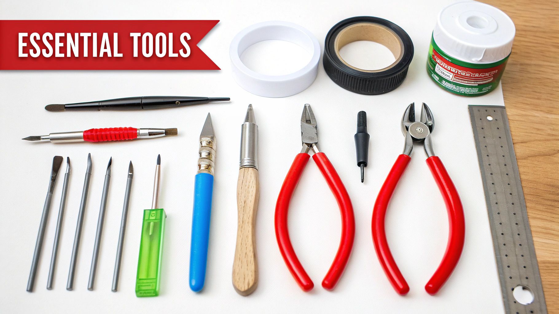 A collection of essential modeling tools, including sprue cutters, a hobby knife, and tweezers, arranged neatly on a cutting mat.