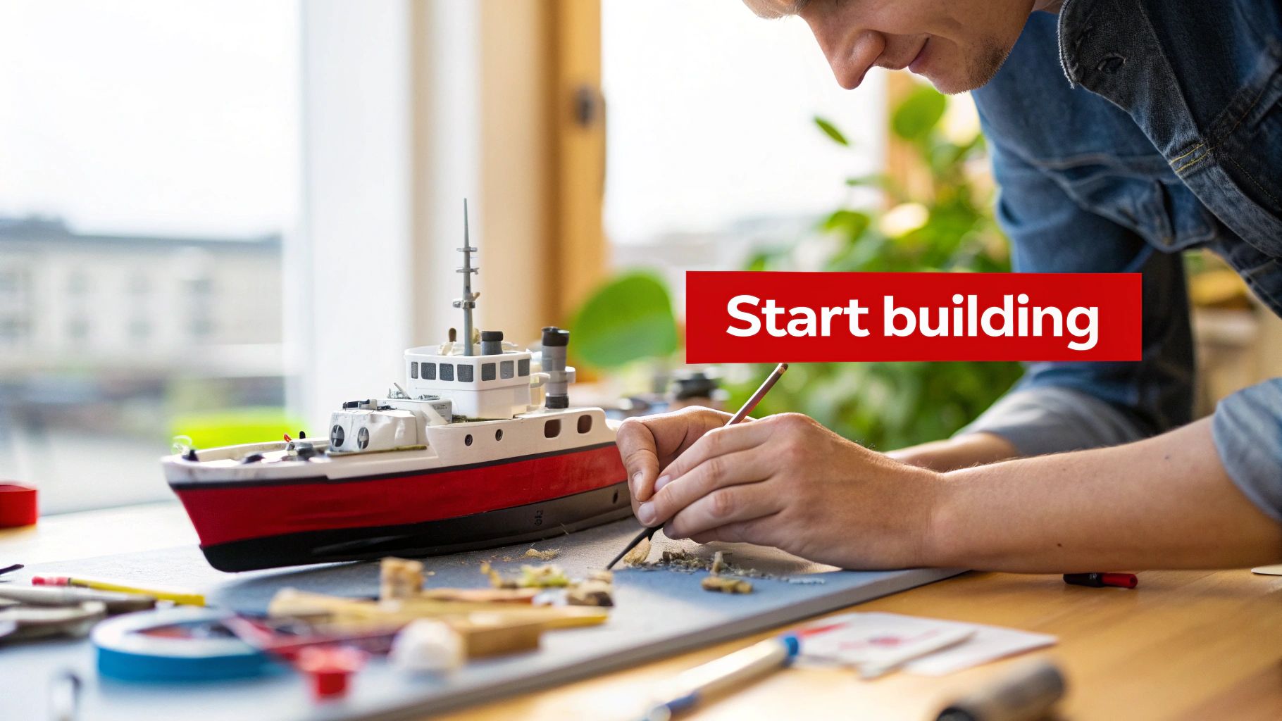 A completed scale model of a fighter jet displayed on a workbench surrounded by modeling tools and paints.