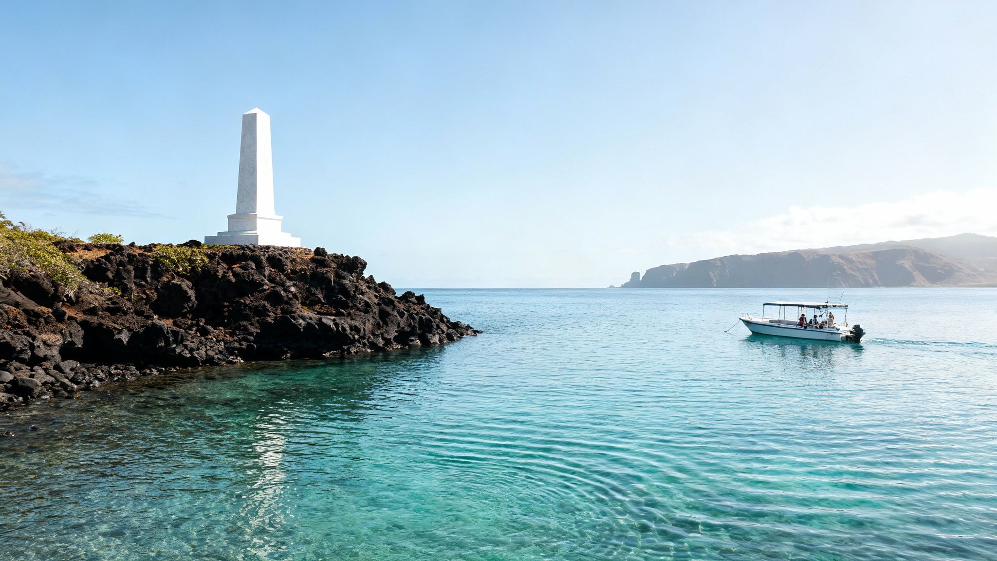 Scenic view of a white obelisk monument on a dark rocky shore next to turquoise water and a boat.