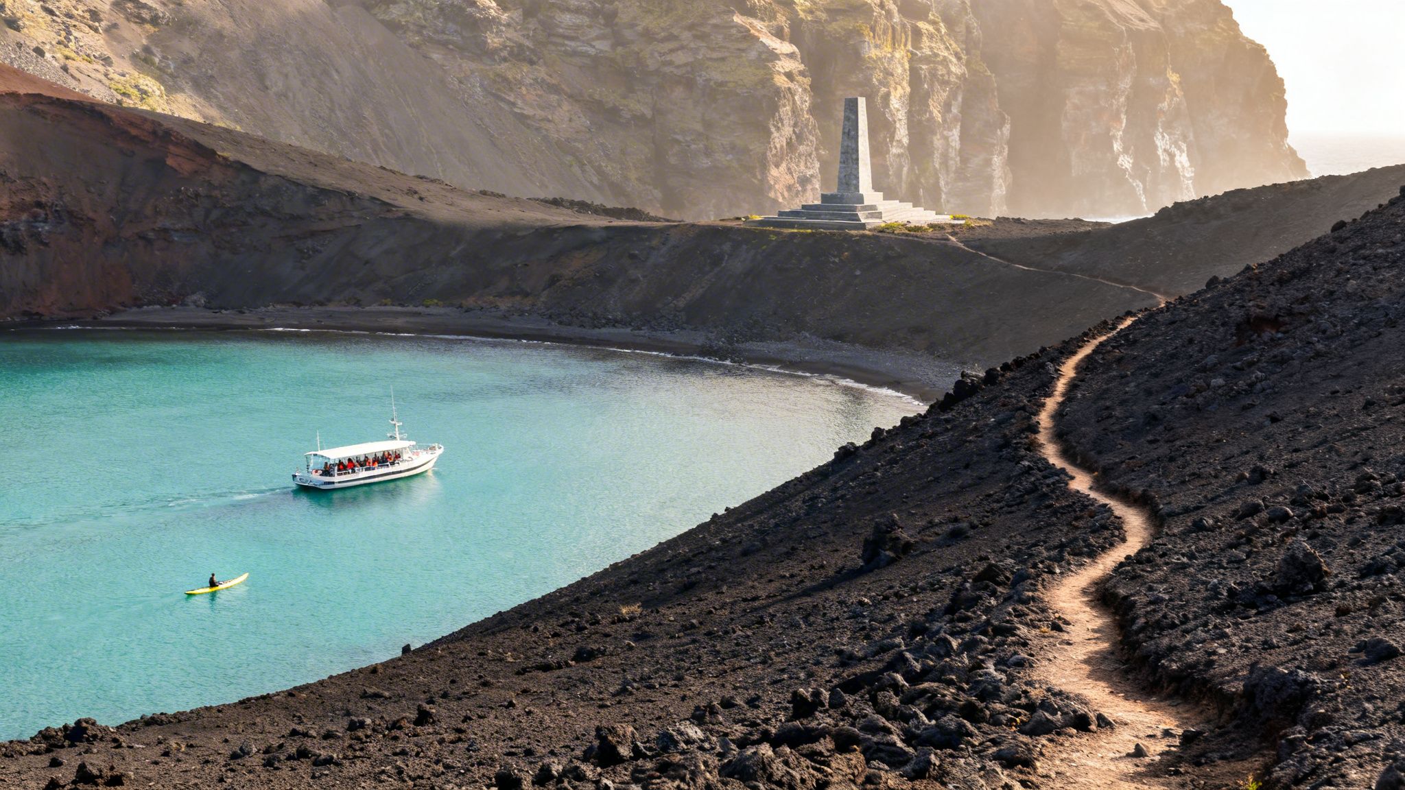 Panoramic view of a bay with turquoise water, a tour boat, kayak, and a monument on volcanic hills.