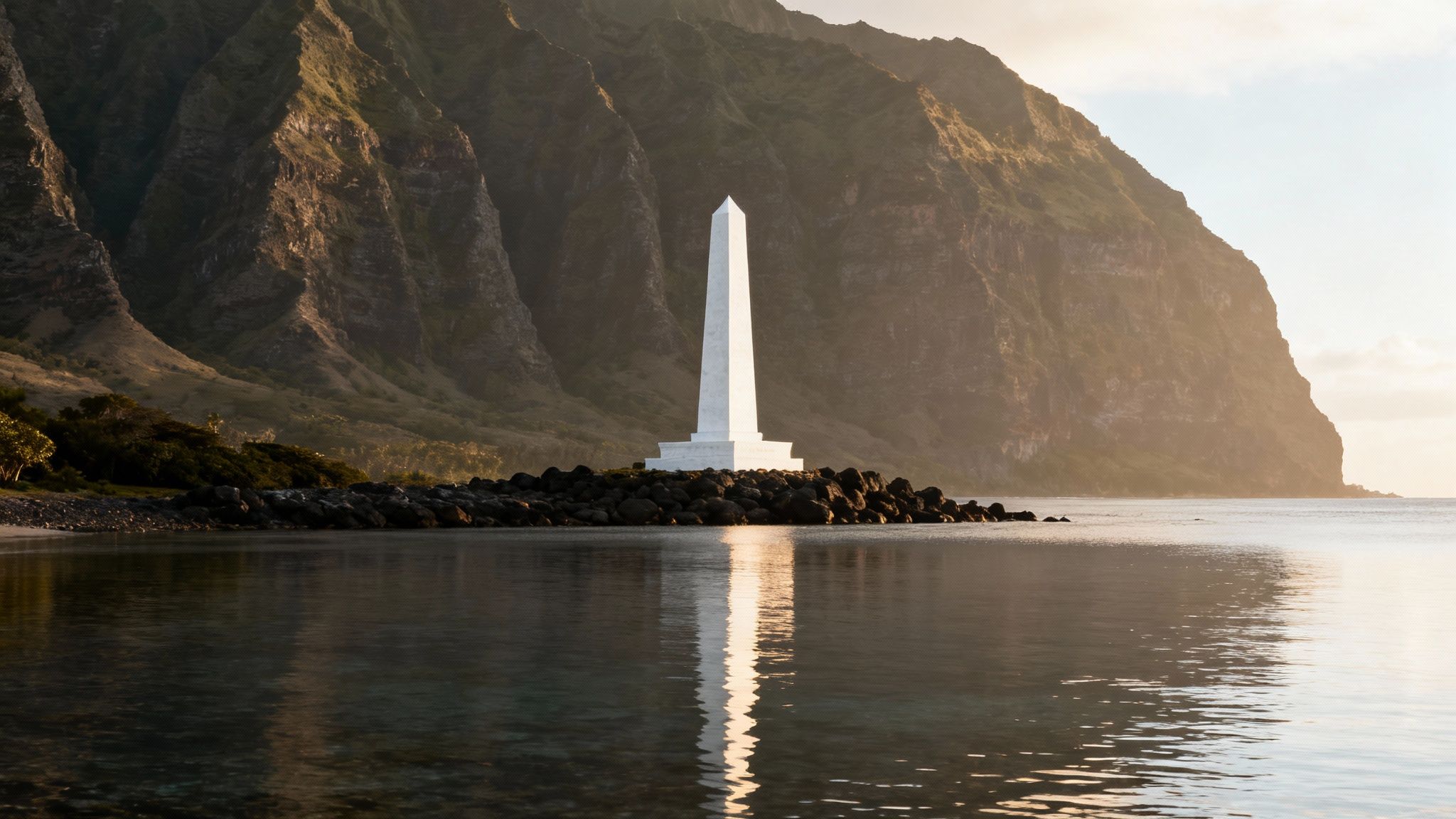 White obelisk monument reflecting in calm water at sunrise with dramatic tropical mountains.