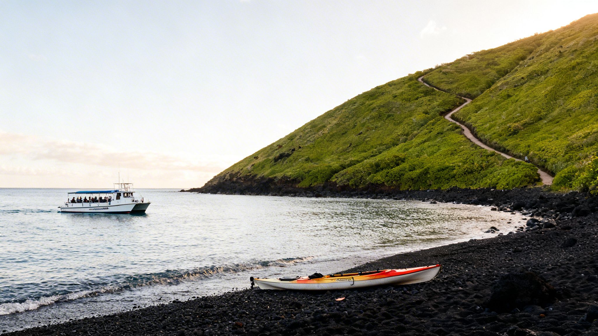 A scenic view of a white boat on the ocean, a green hillside with a winding path, and a kayak on a black sand beach.