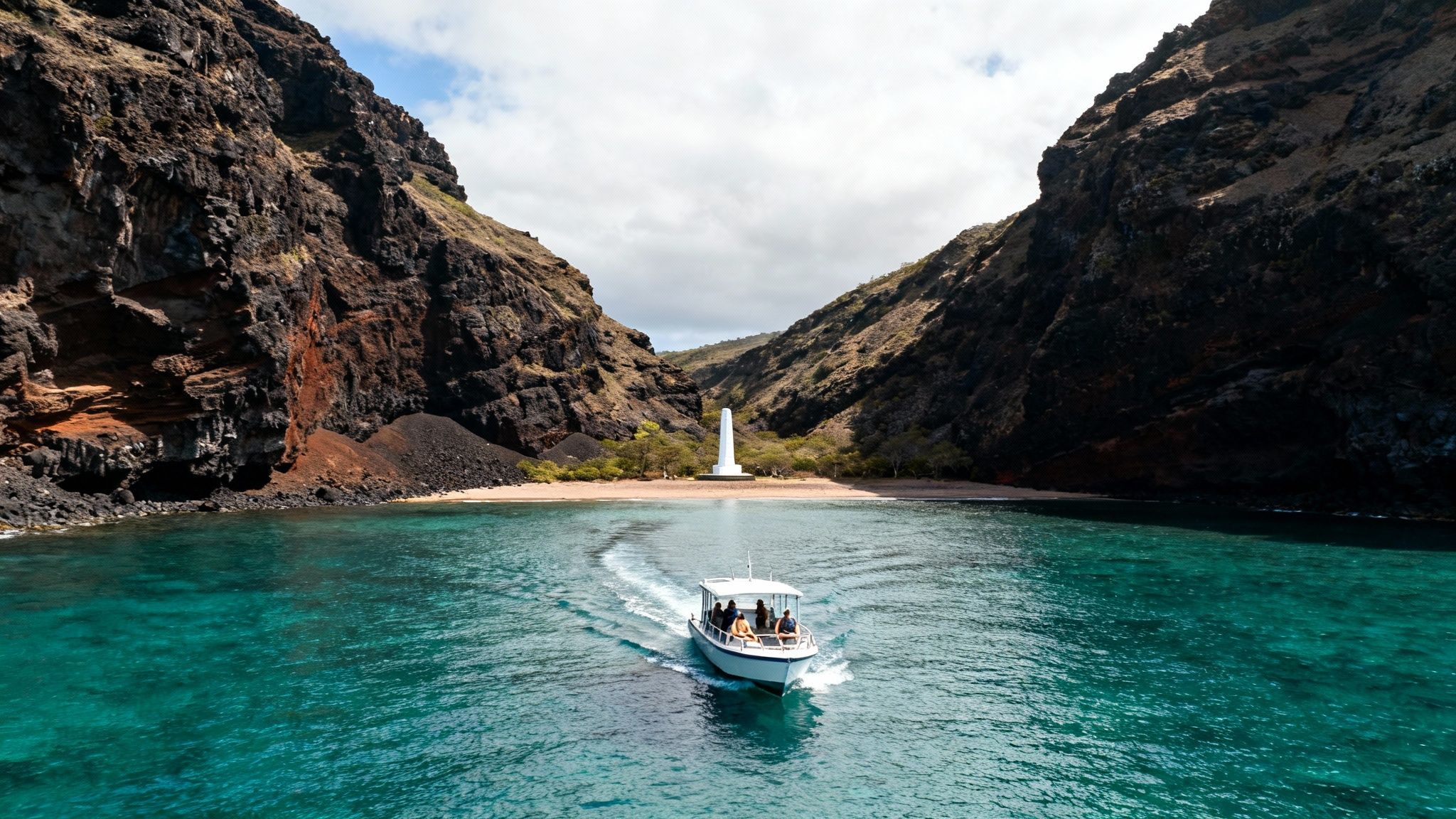 A tour boat on turquoise water approaches a secluded bay with towering cliffs and a white obelisk.
