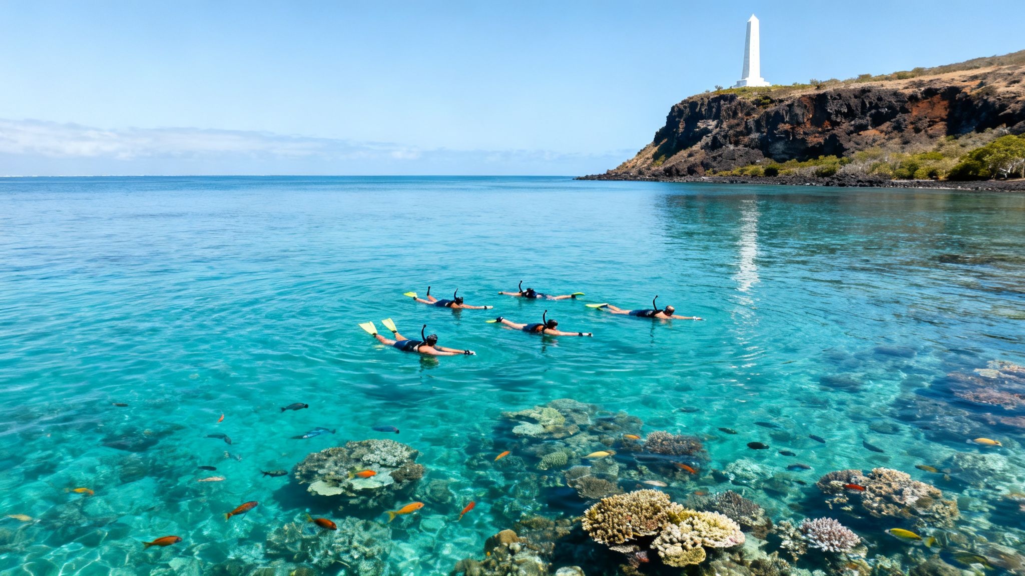 A group of snorkelers swim over vibrant coral reefs near the Captain Cook monument on a sunny day.