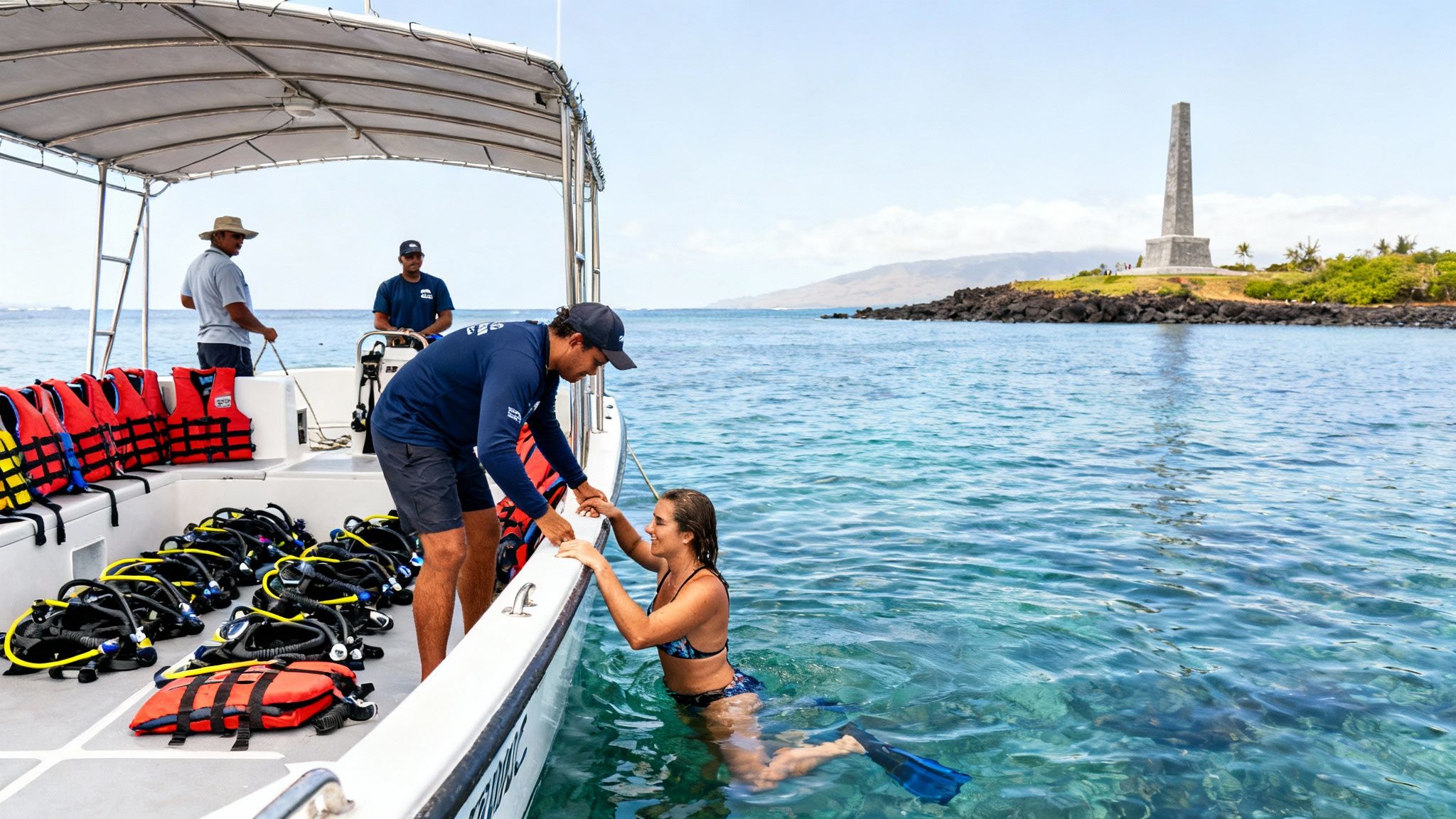 A boat guide assists a woman entering clear ocean water for snorkeling near the Captain Cook Monument.
