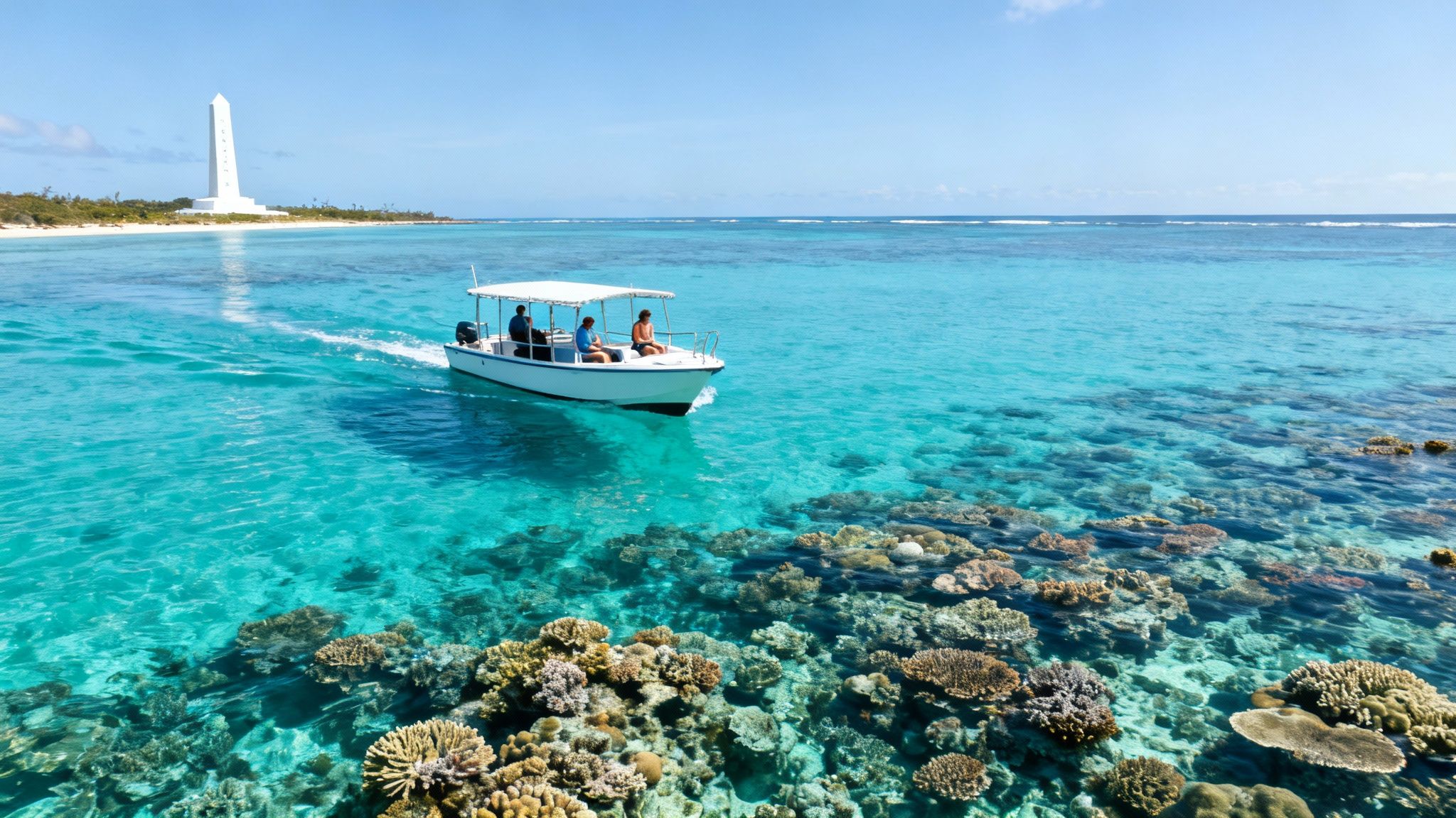Boat carrying tourists glides over vibrant coral reefs in turquoise tropical waters near a white monument.