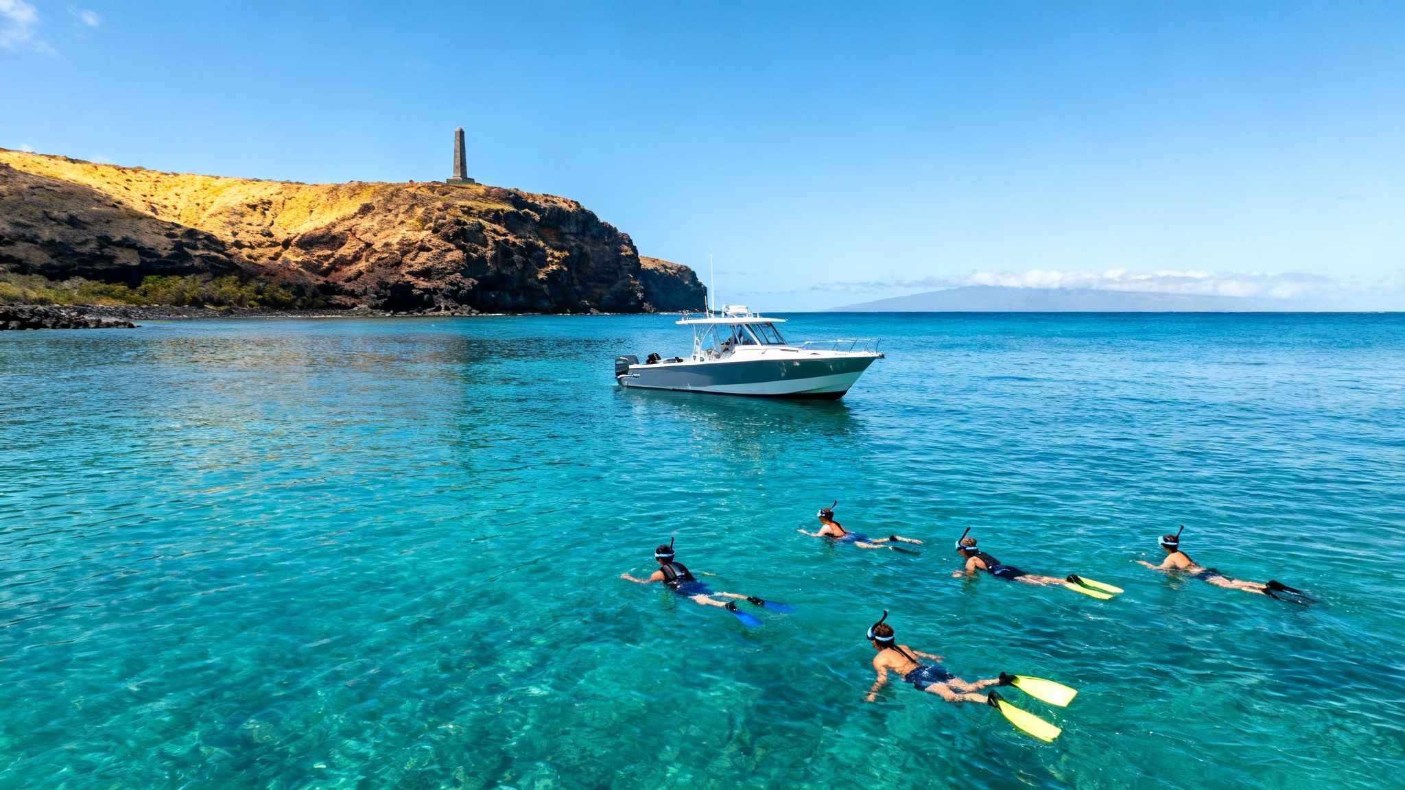 People snorkeling in clear blue water near a boat, a rocky island with a monument, and distant mountains.
