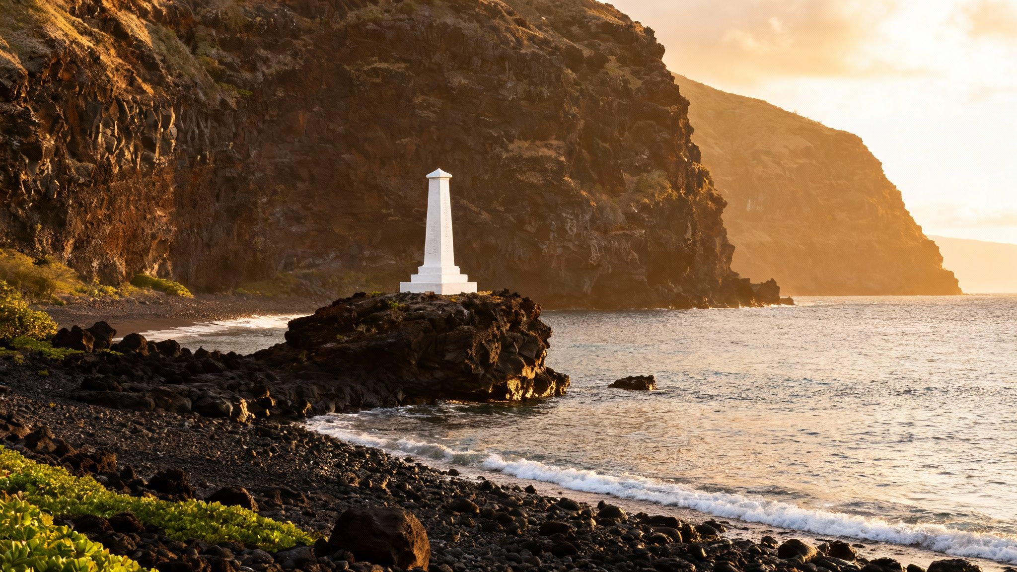 Sunrise illuminates a white monument on a black rock formation by the sea, with dark cliffs.
