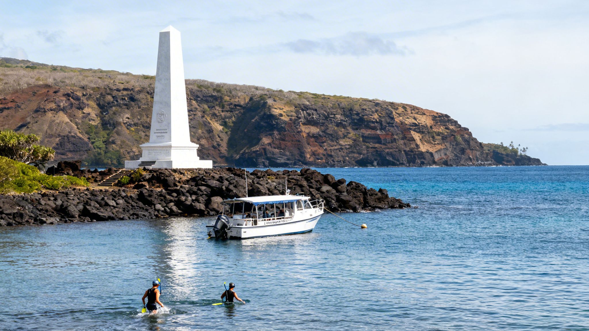 Scenic view of Kealakekua Bay with snorkelers, a boat, and the Captain Cook Monument.