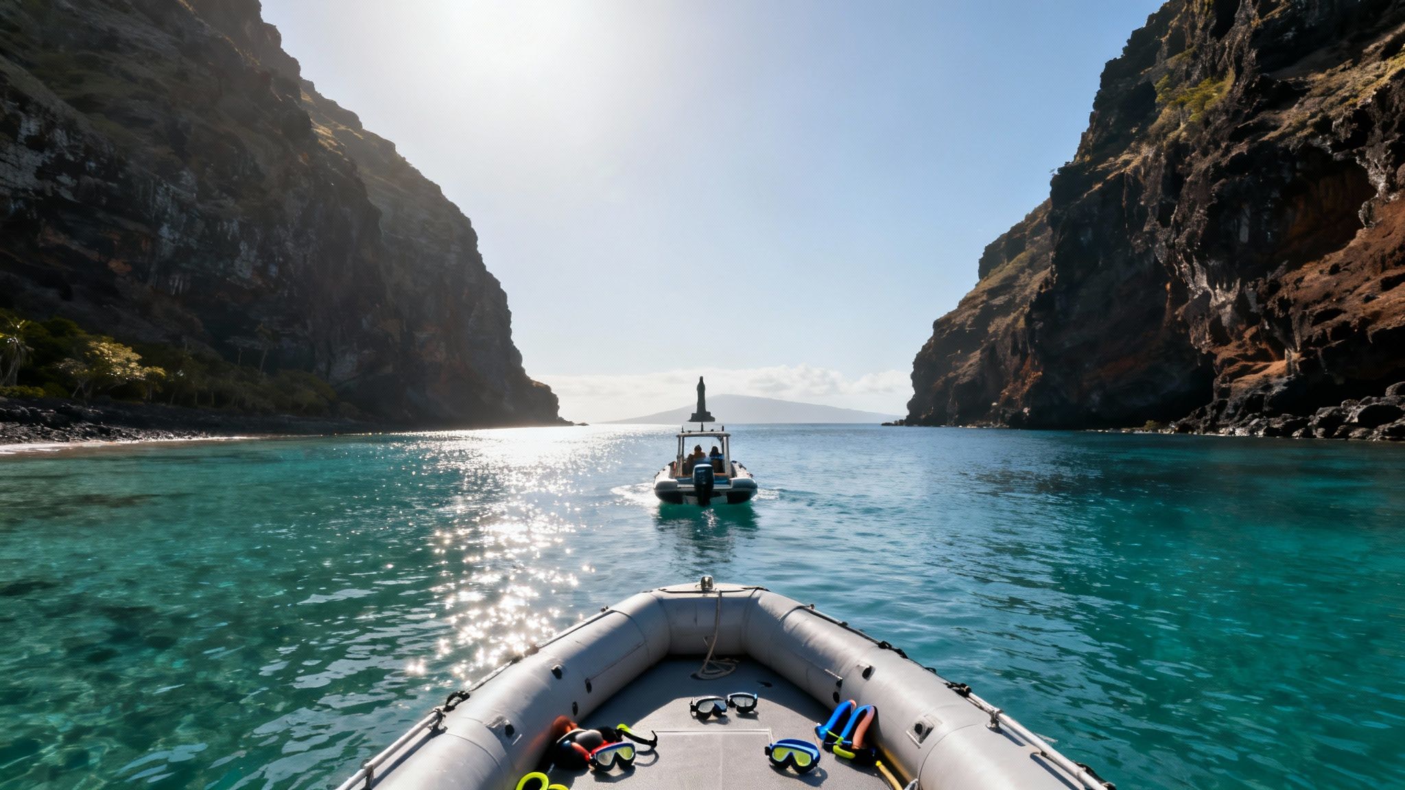 View from a boat with snorkel gear, approaching another boat in a sunny tropical bay between high cliffs.