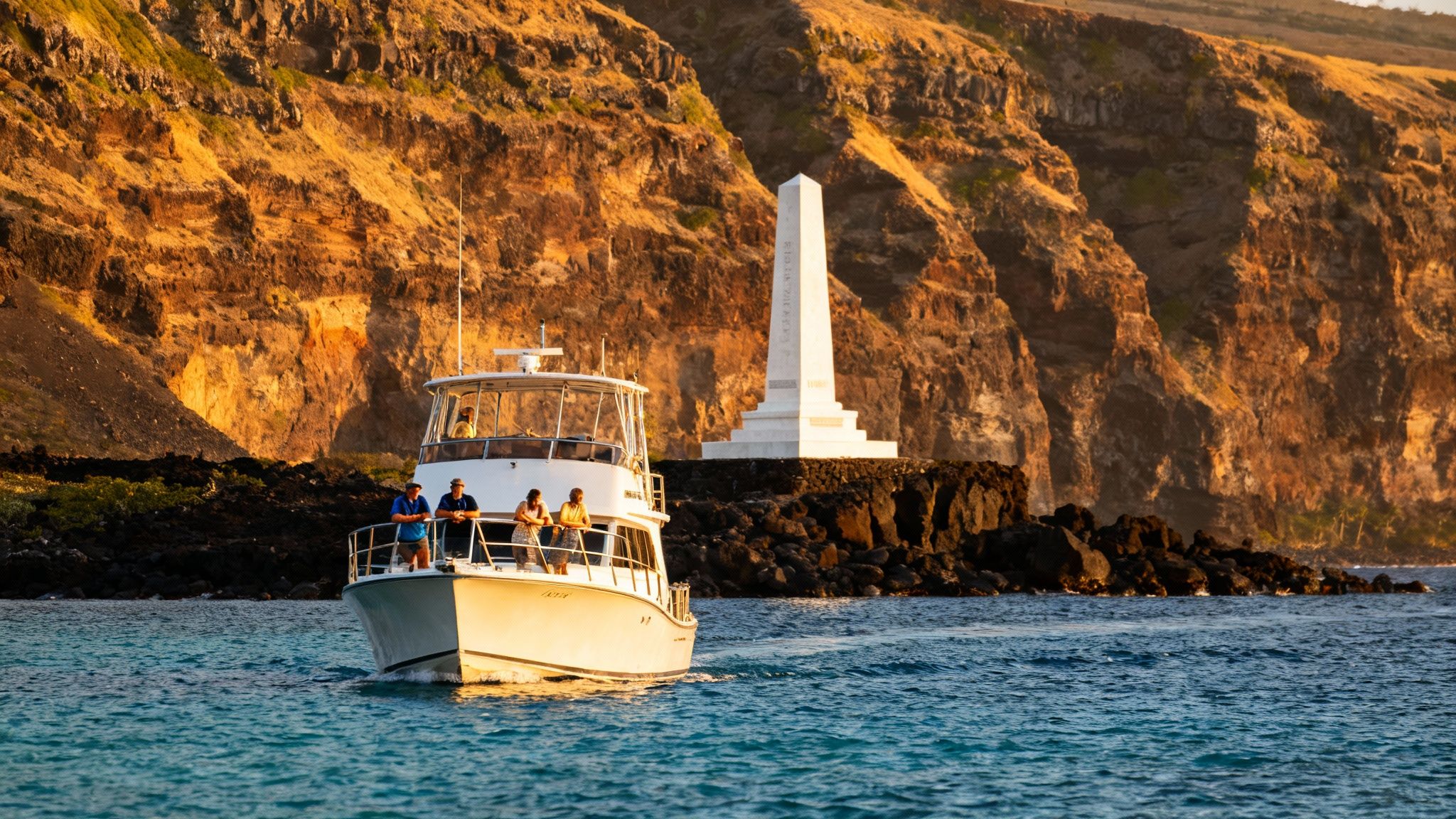 Tourists on a boat sailing past the white Captain Cook monument against golden cliffs at sunset.