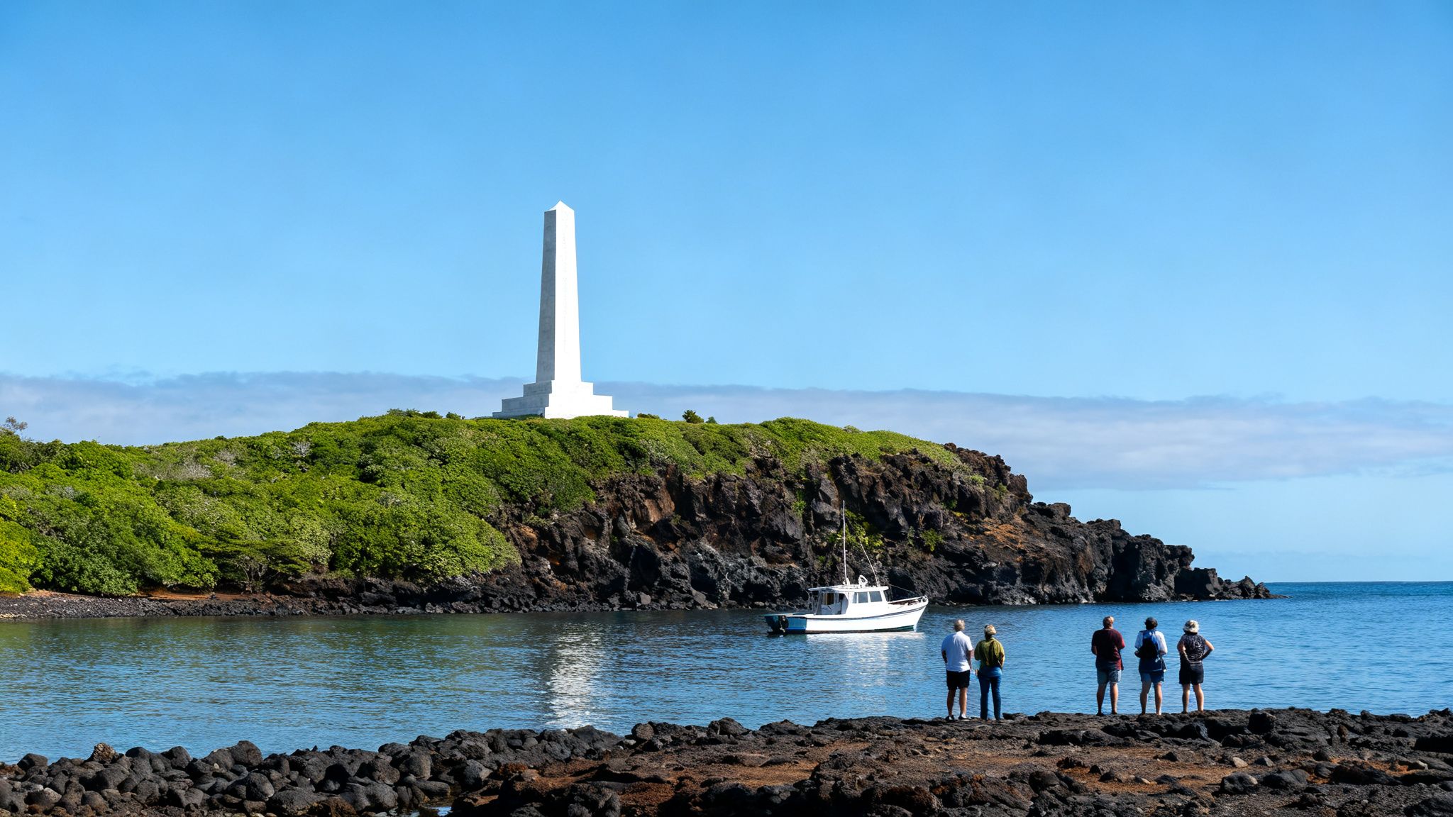 Group of people on a rocky shore admiring a white monument on a green island with a boat in the water.
