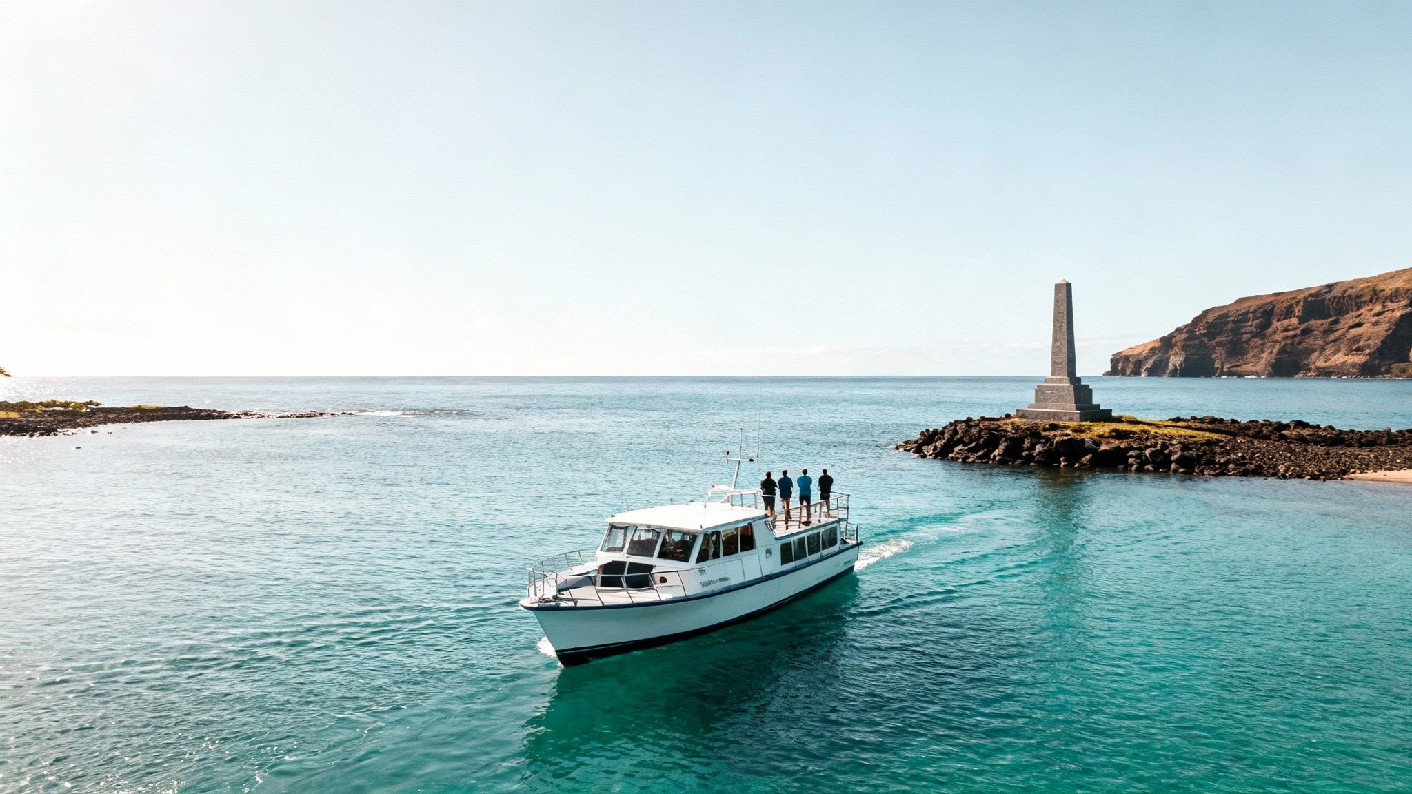 A boat with people in turquoise water approaches the Captain Cook Monument on a rocky islet near a lush coastline.