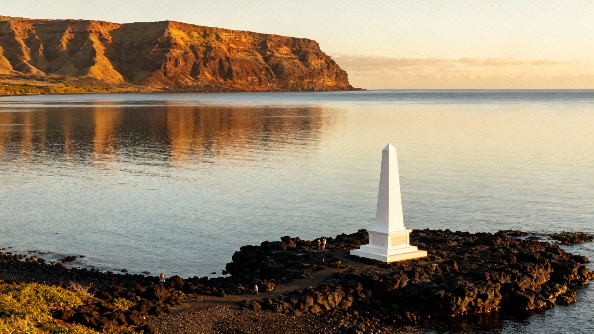 White Captain Cook Monument on black lava rock, with tranquil Kealakekua Bay and towering cliffs at sunrise.