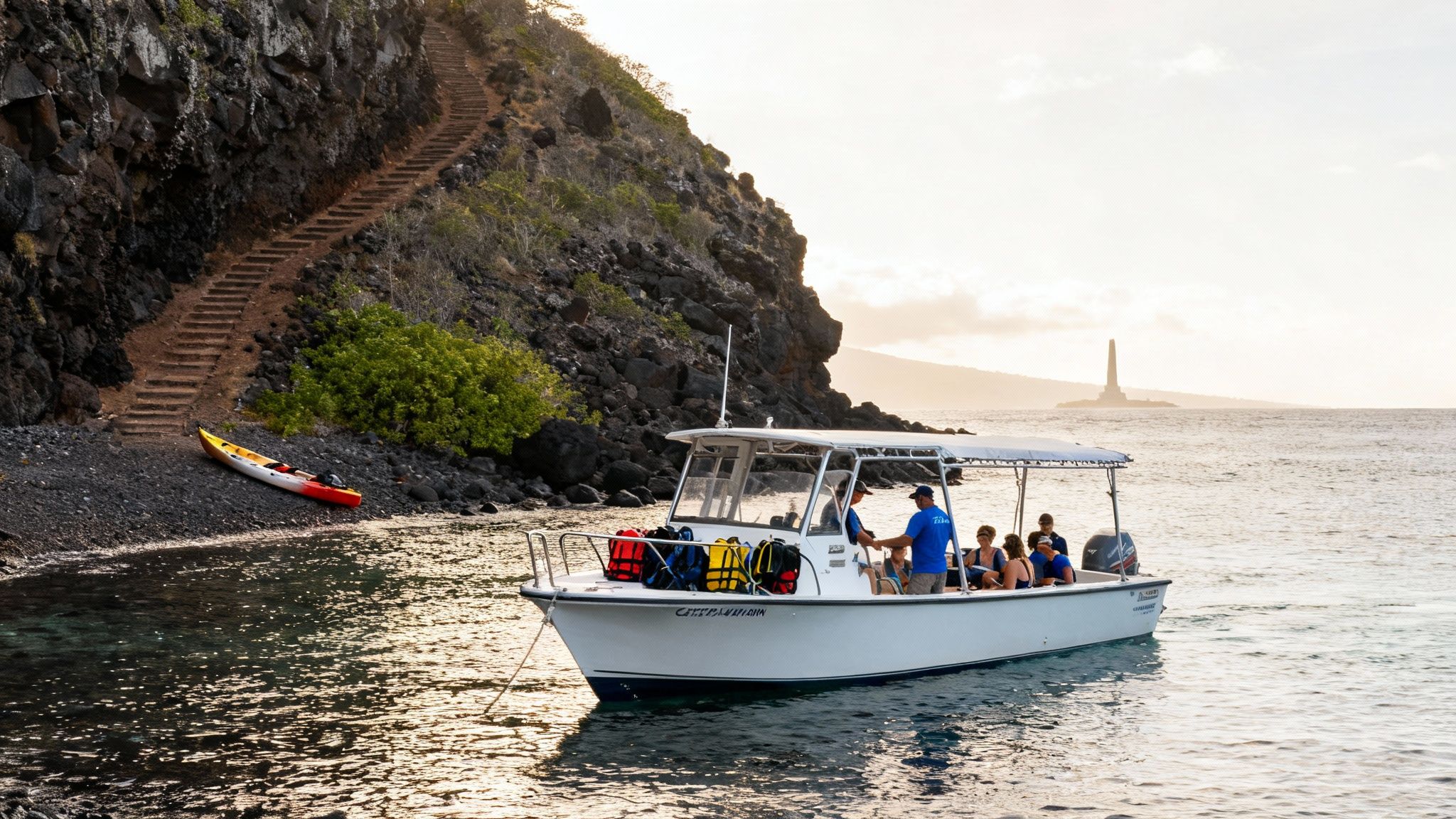 A tour boat with passengers in a Hawaiian bay near a rocky shore with stairs and a kayak, with a distant monument.