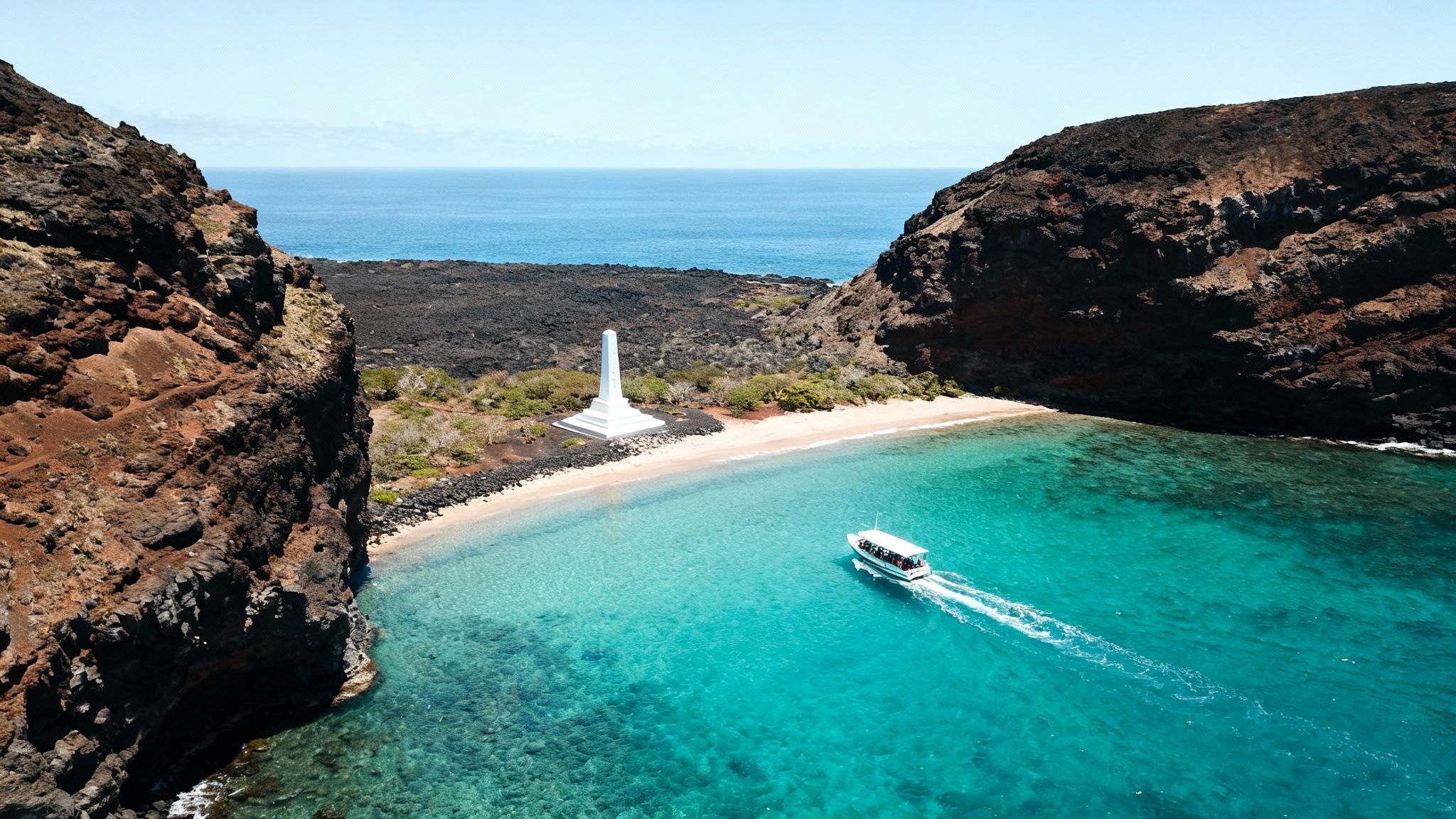 Aerial view of a boat in turquoise Kealakekua Bay, Hawaii, with the white Captain Cook Monument on shore.