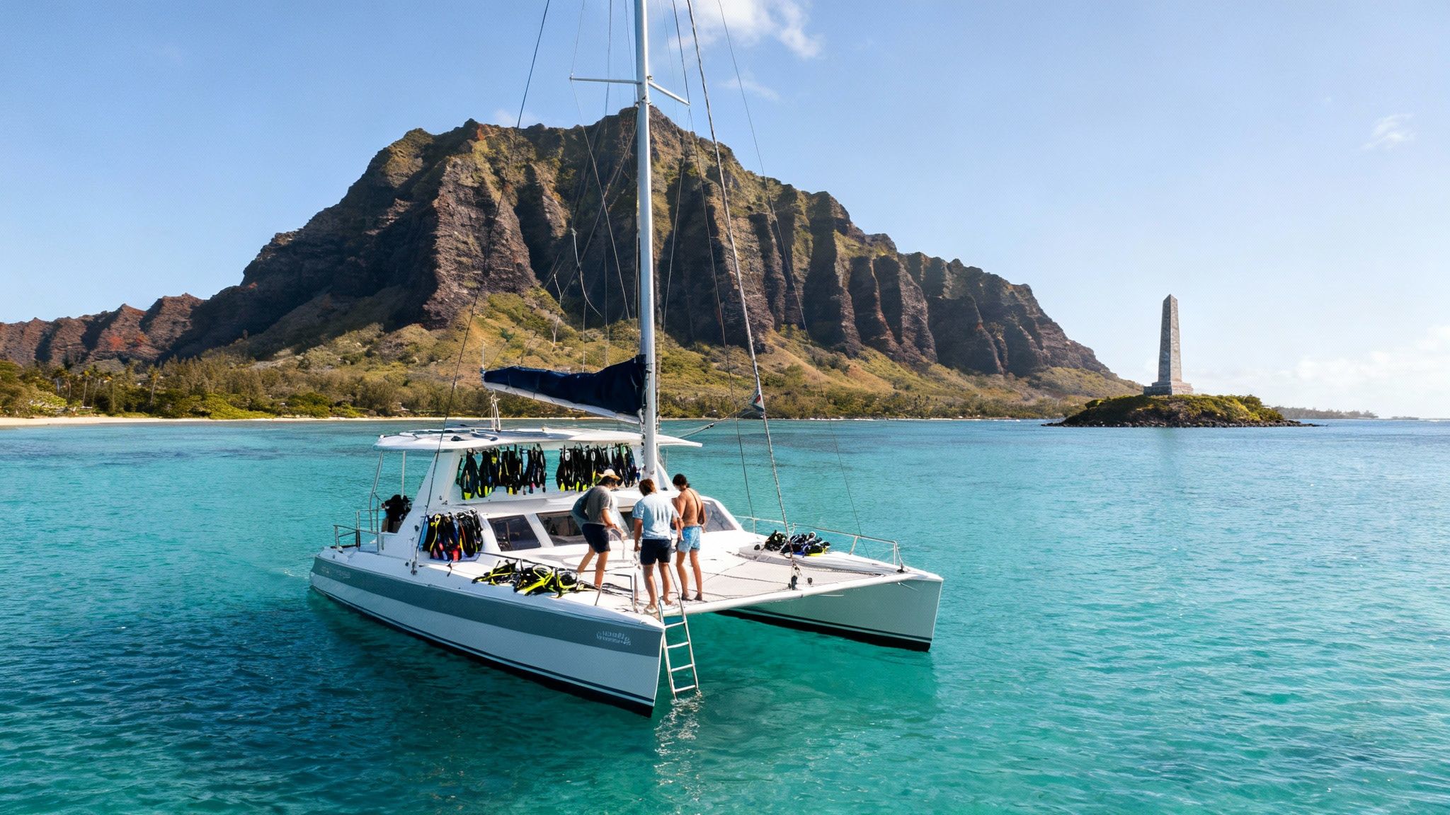 Scenic view of a catamaran with dive gear, lush mountains, and the Captain Cook Monument.