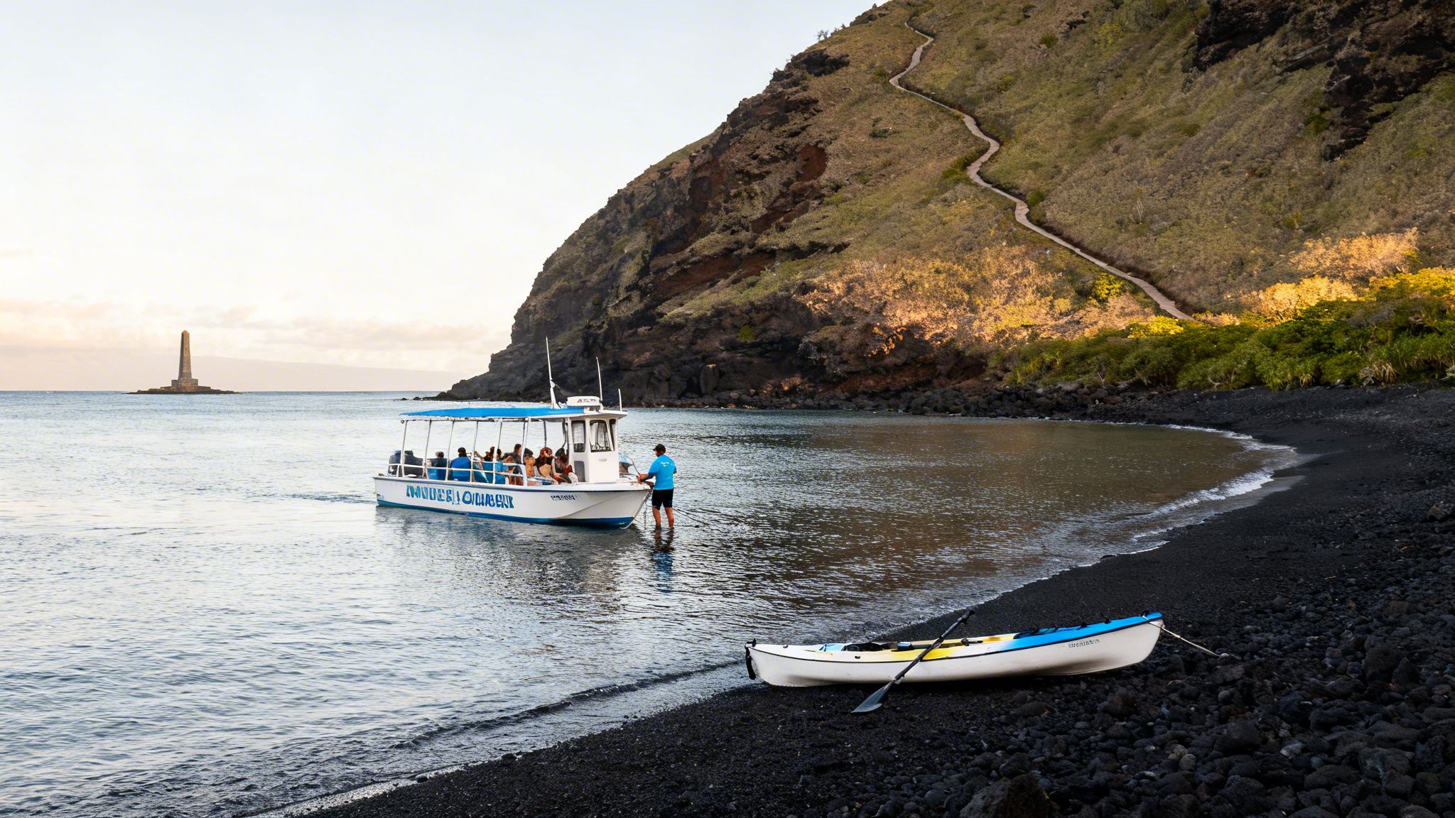 A tour boat near a black sand beach with a monument in the distance and a path up a hill.