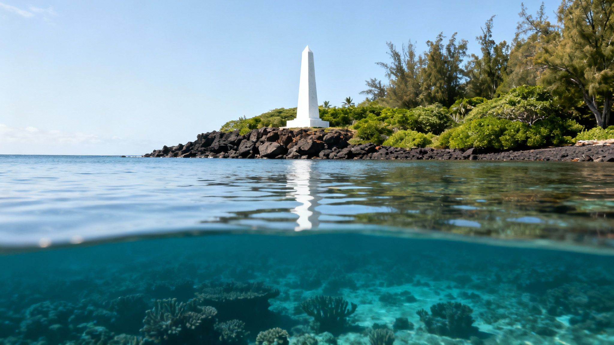Split-level view of a tropical ocean with an obelisk on a rocky island above and vibrant coral reefs below.