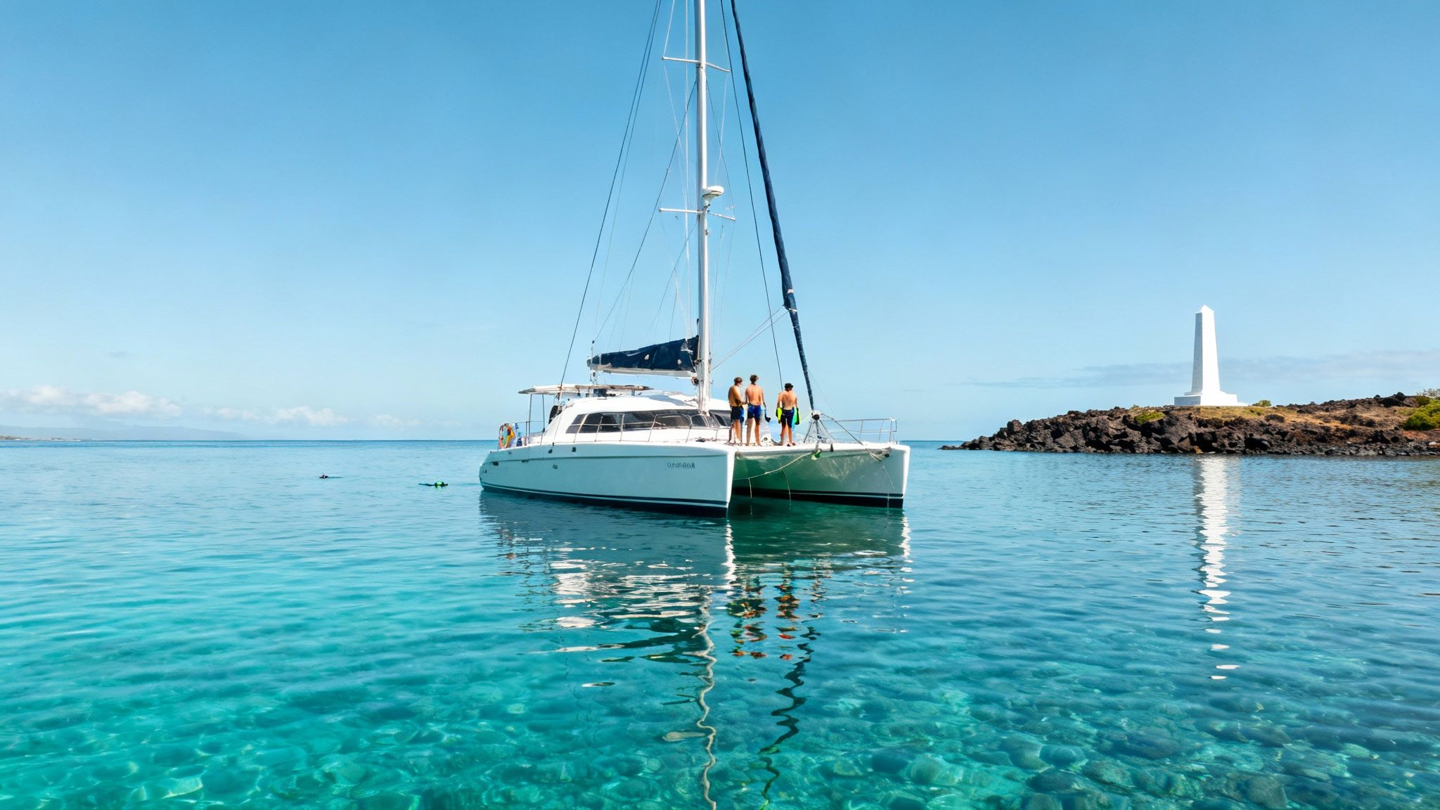 A large group of yellow fish swimming over a coral reef in clear blue water.