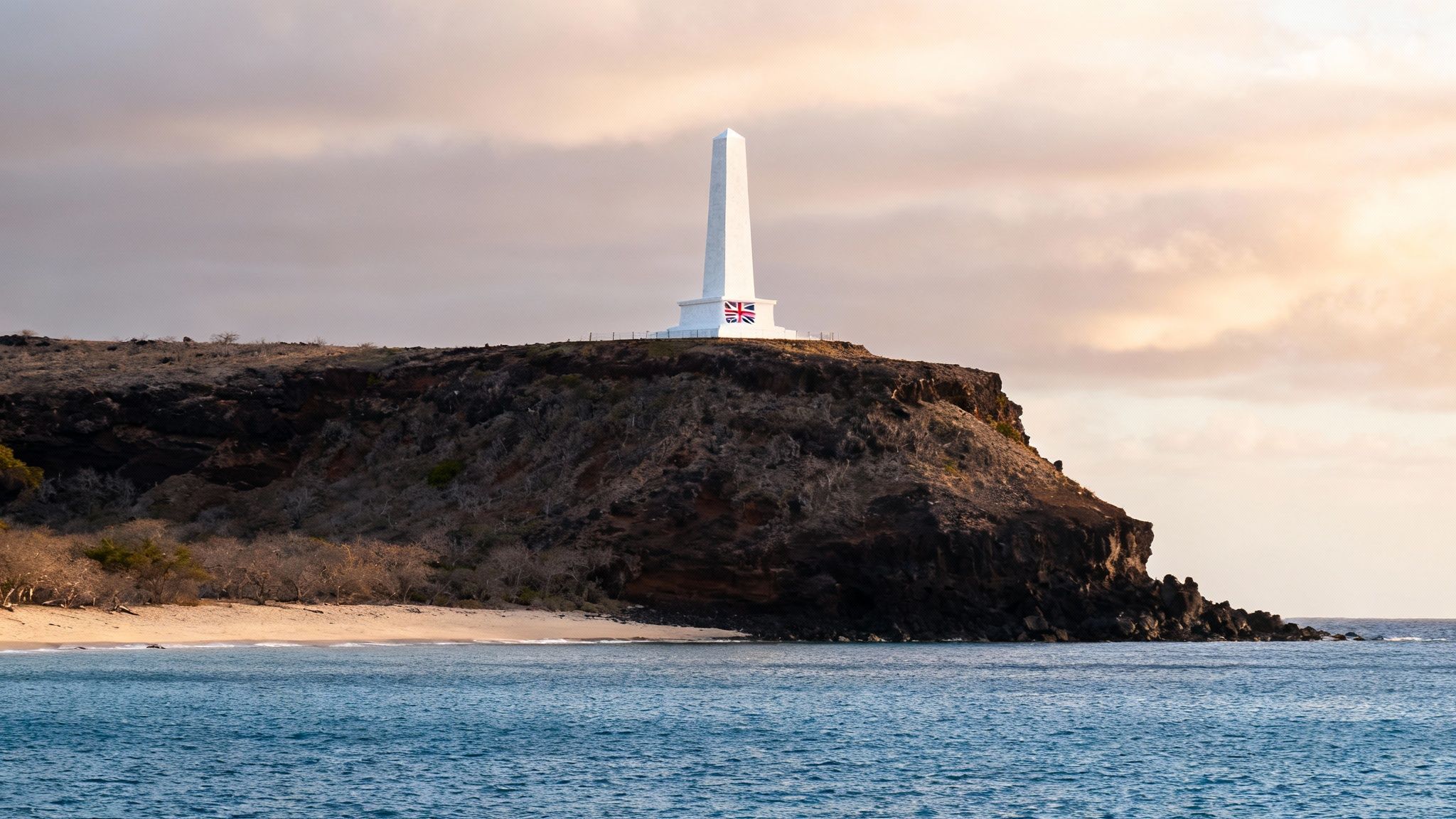 The white Captain Cook Monument standing on the shore of Kealakekua Bay.