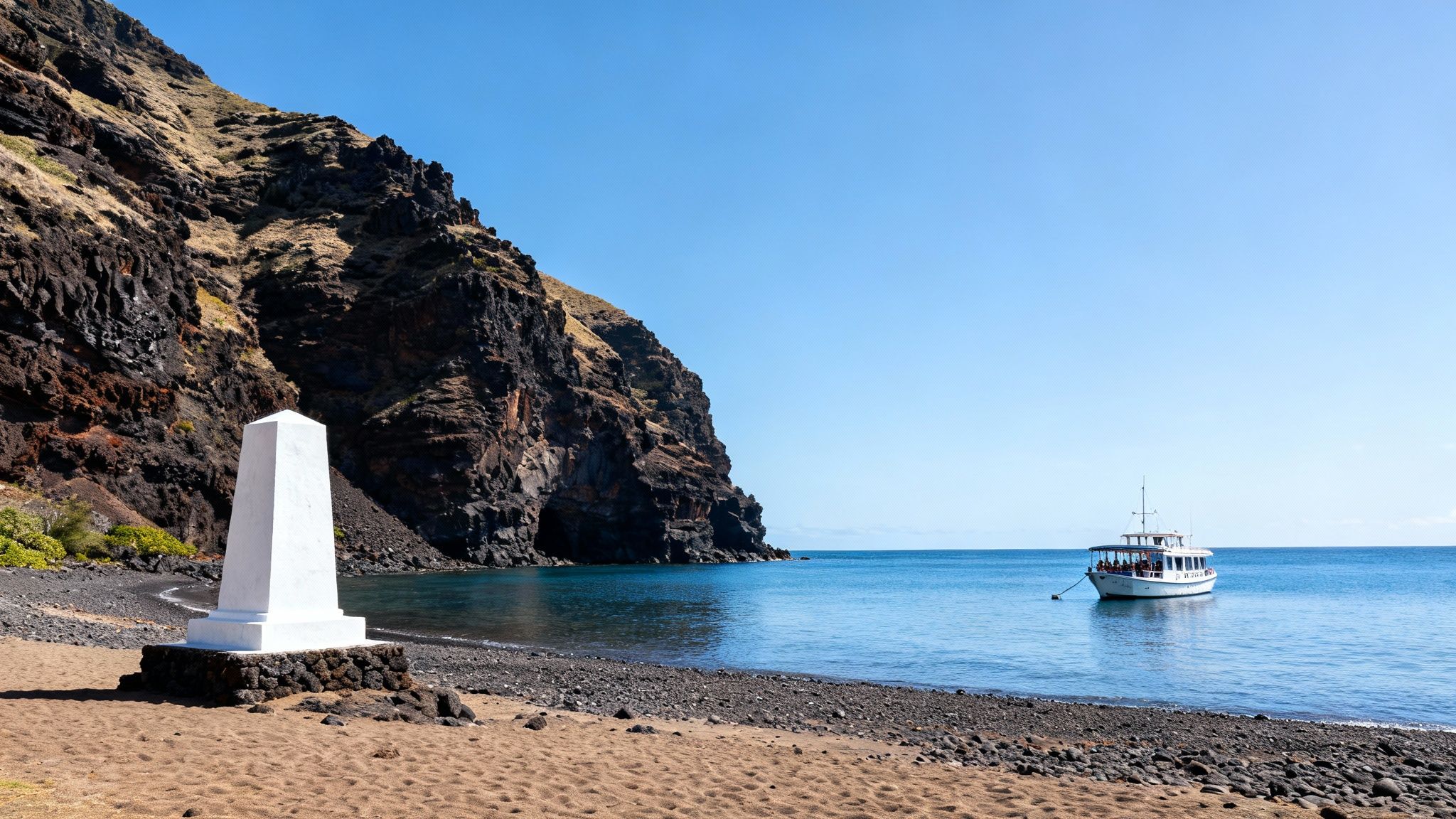 White monument on a Hawaiian beach with dark cliffs, a boat in the clear blue ocean, and a bright sky.