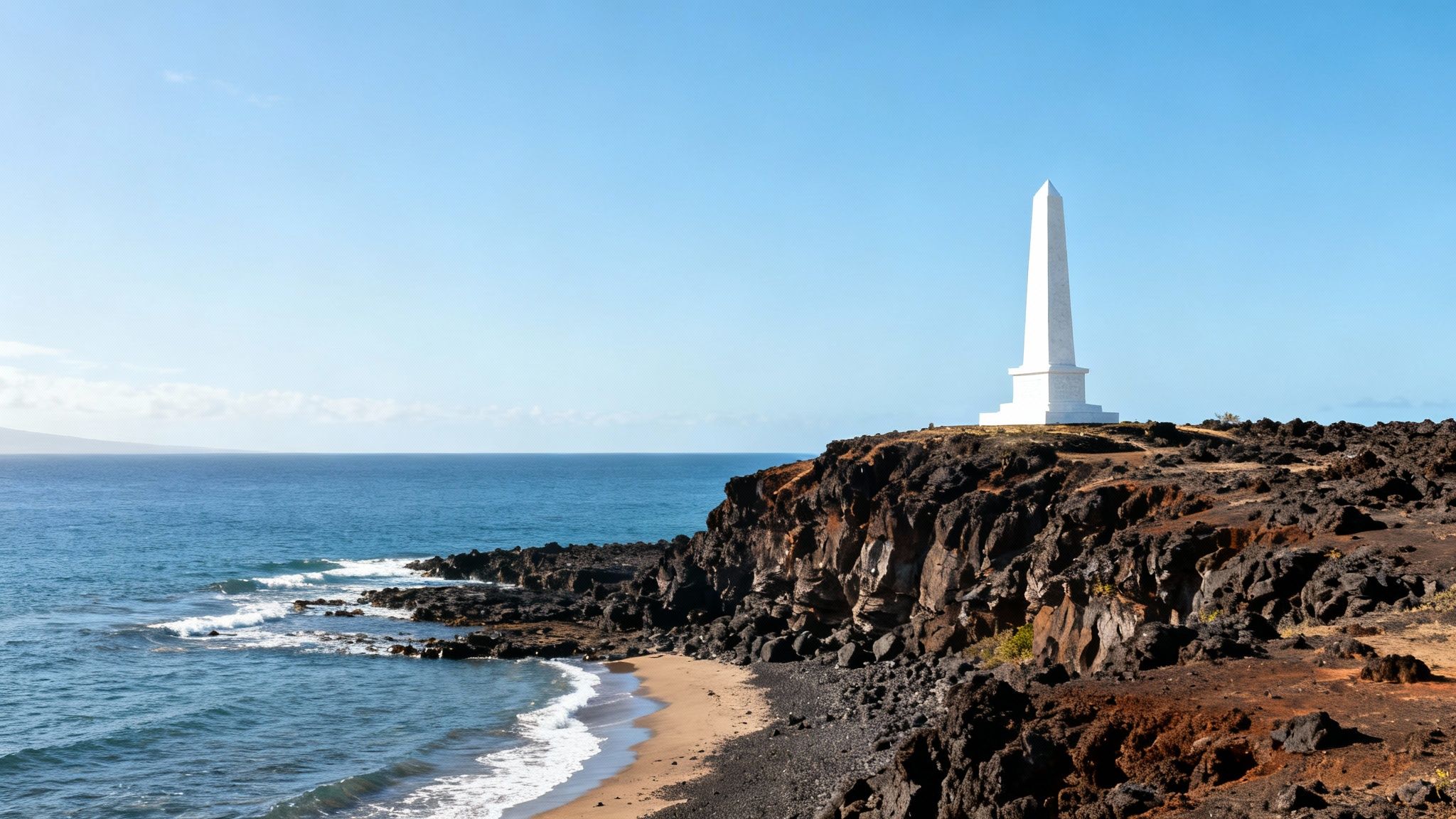 White obelisk monument on a rugged volcanic cliff overlooking a serene blue ocean with a sandy beach.