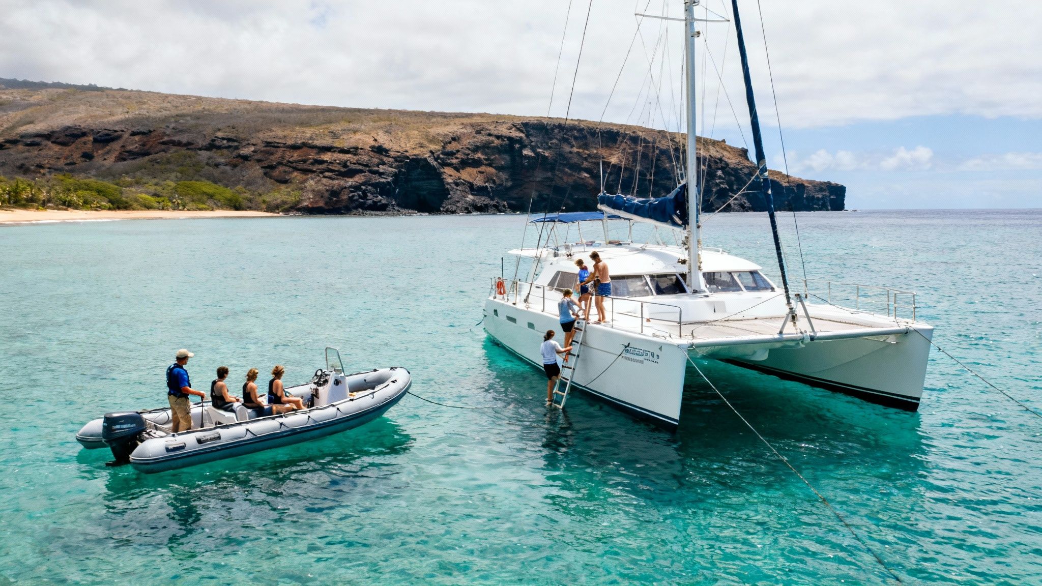 People enjoying a boat tour and snorkeling from a catamaran and a small dinghy near a tropical island.