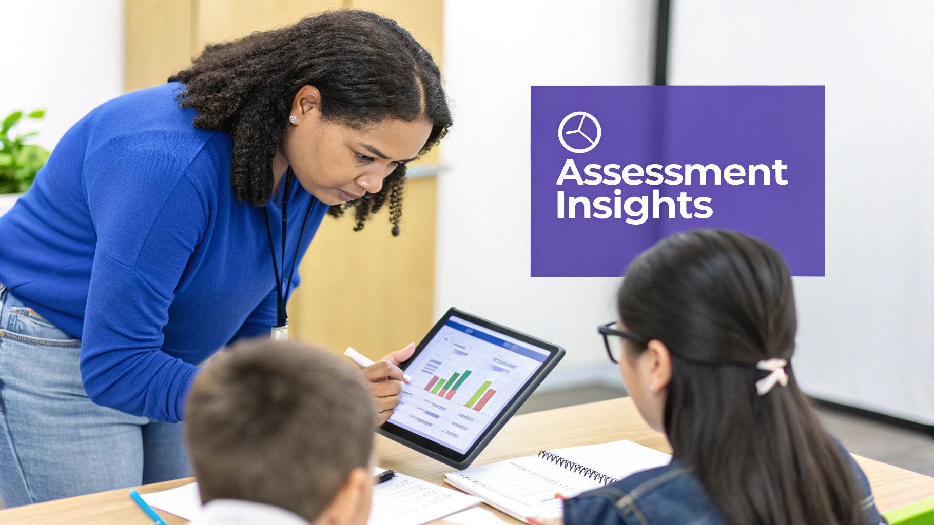 A teacher in a blue shirt shows two students performance insights on a tablet with charts.
