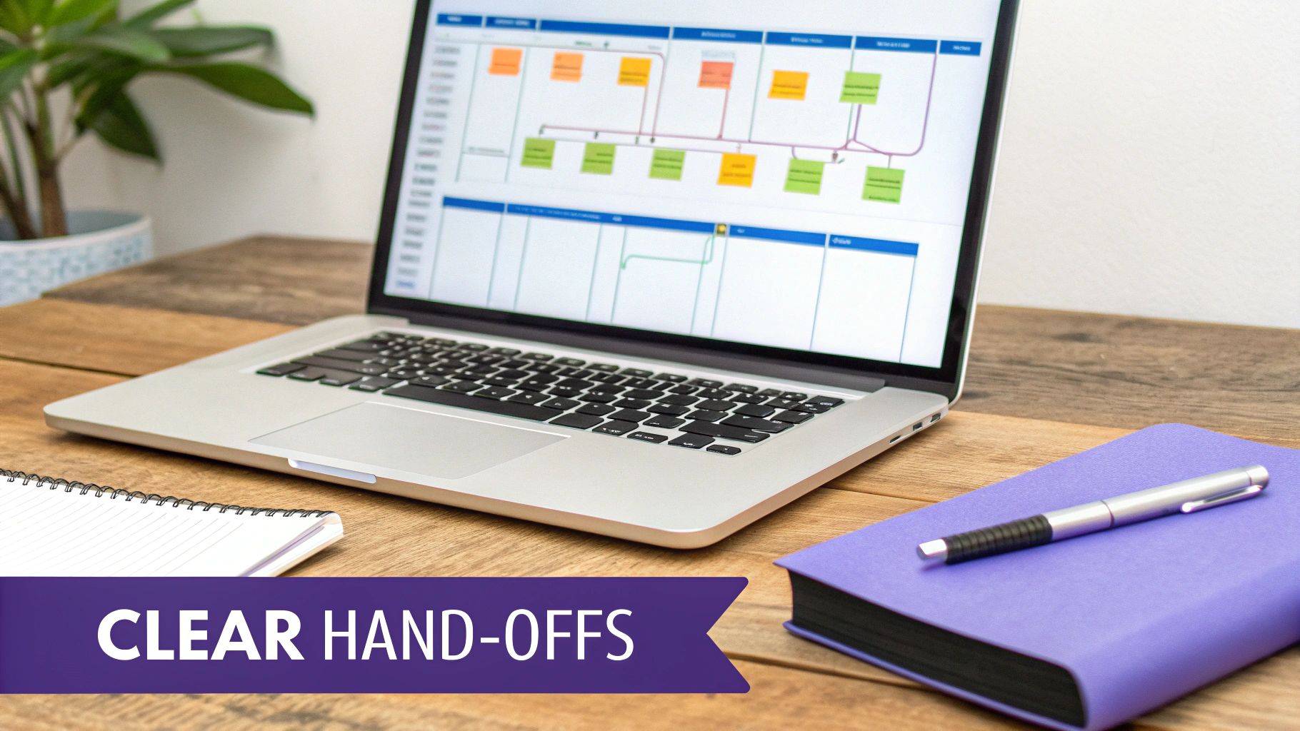 Laptop on a wooden desk displaying a colorful workflow diagram, with notebooks and a pen.